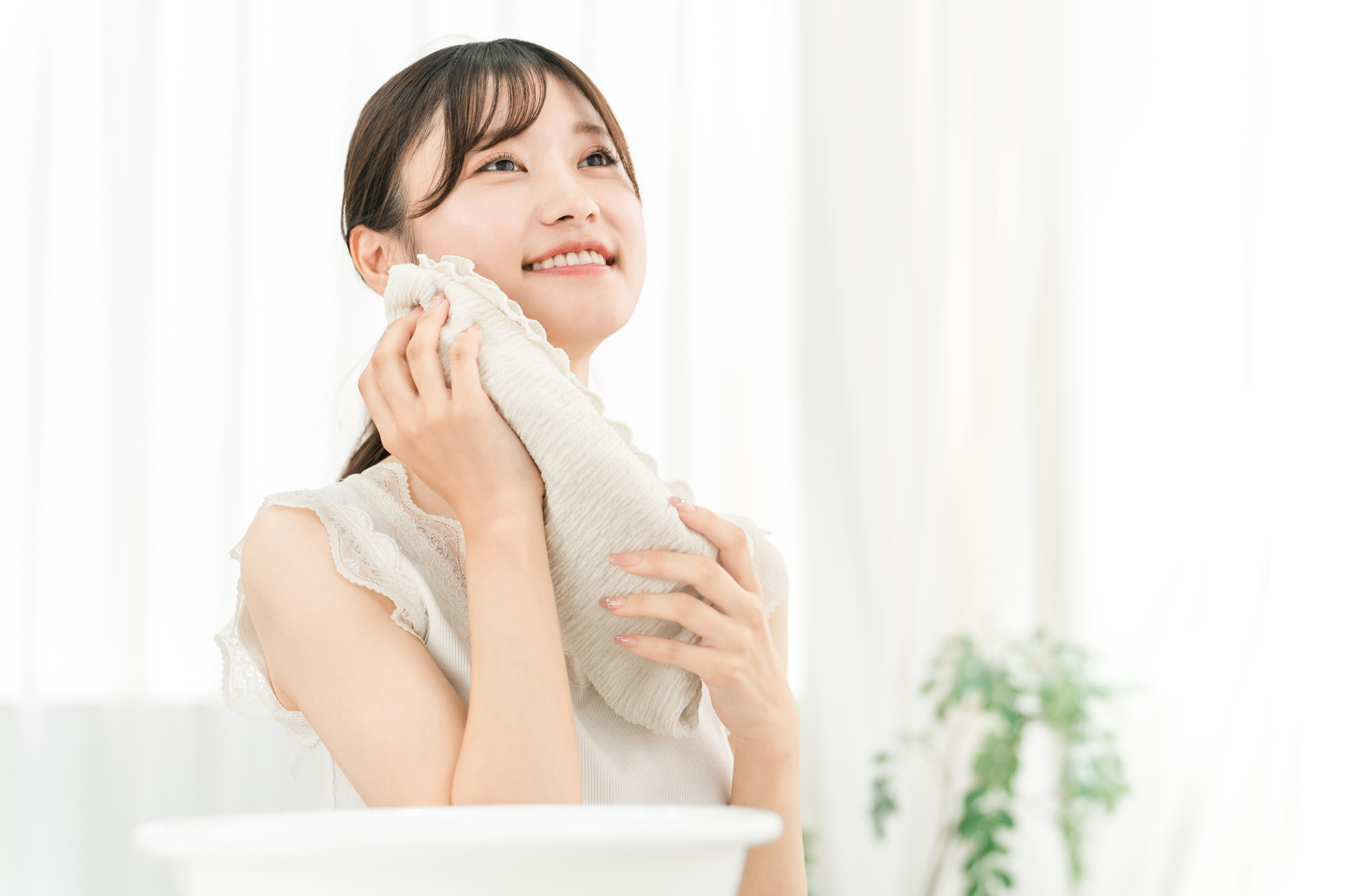 洗顔後にタオルで顔を拭く女性