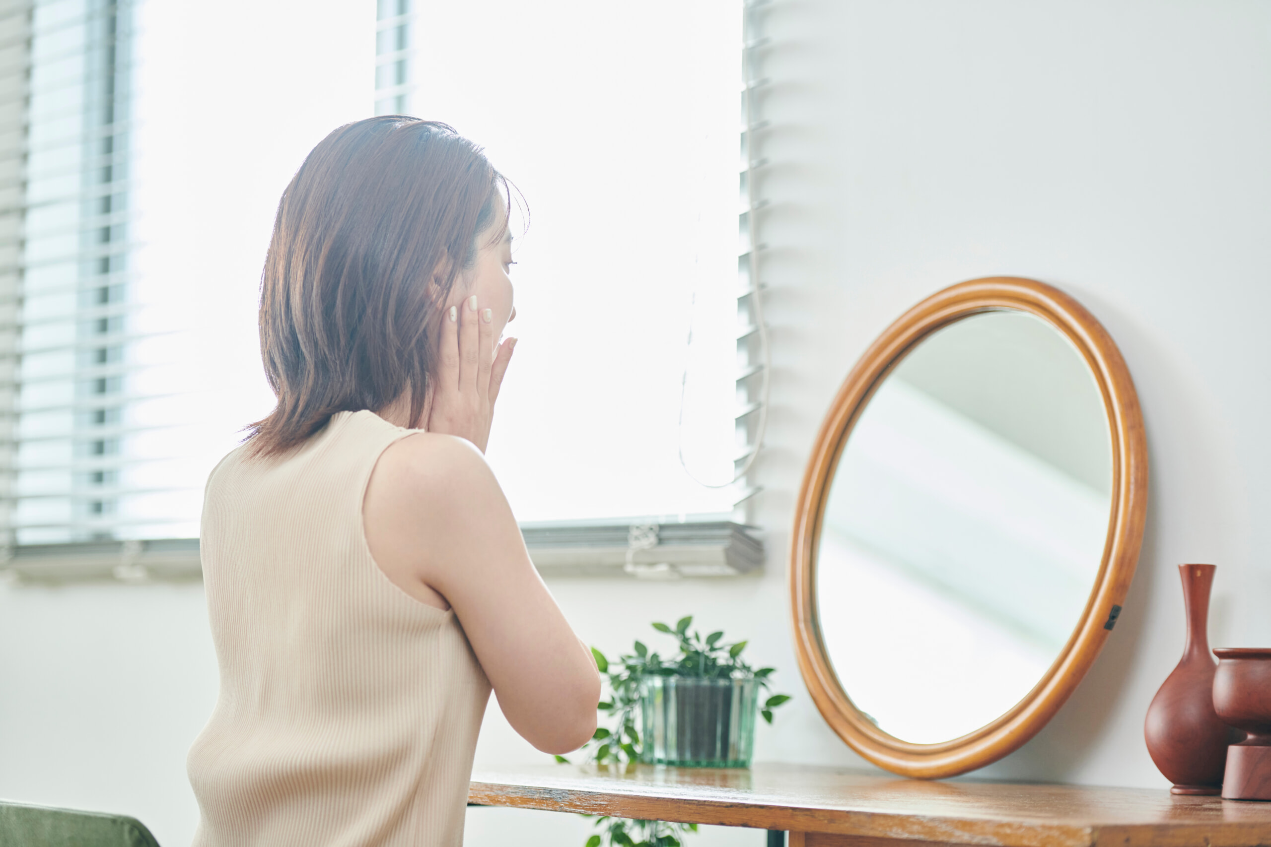 鏡でスキンケアする女性