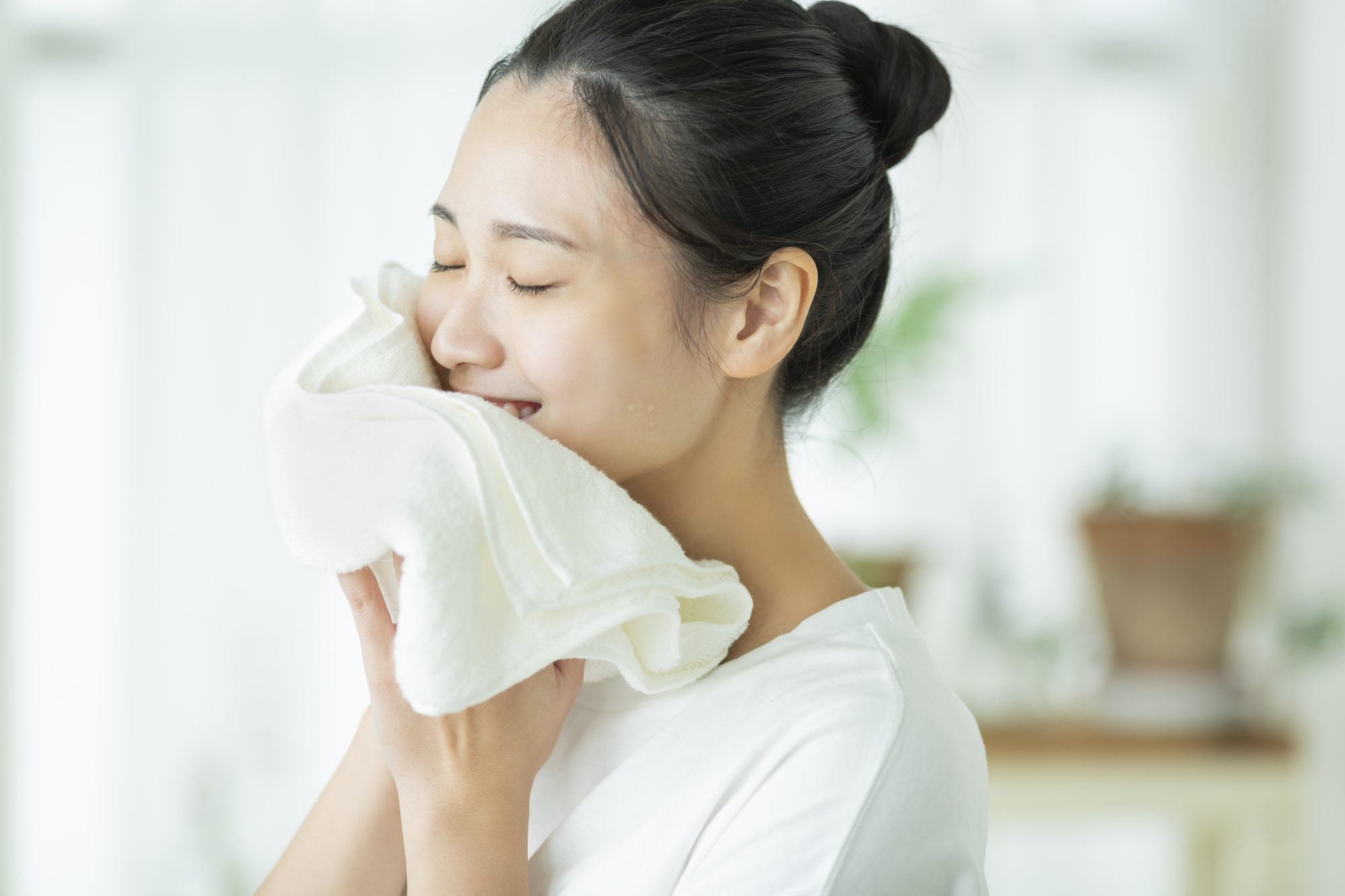 タイルで顔を拭く女性