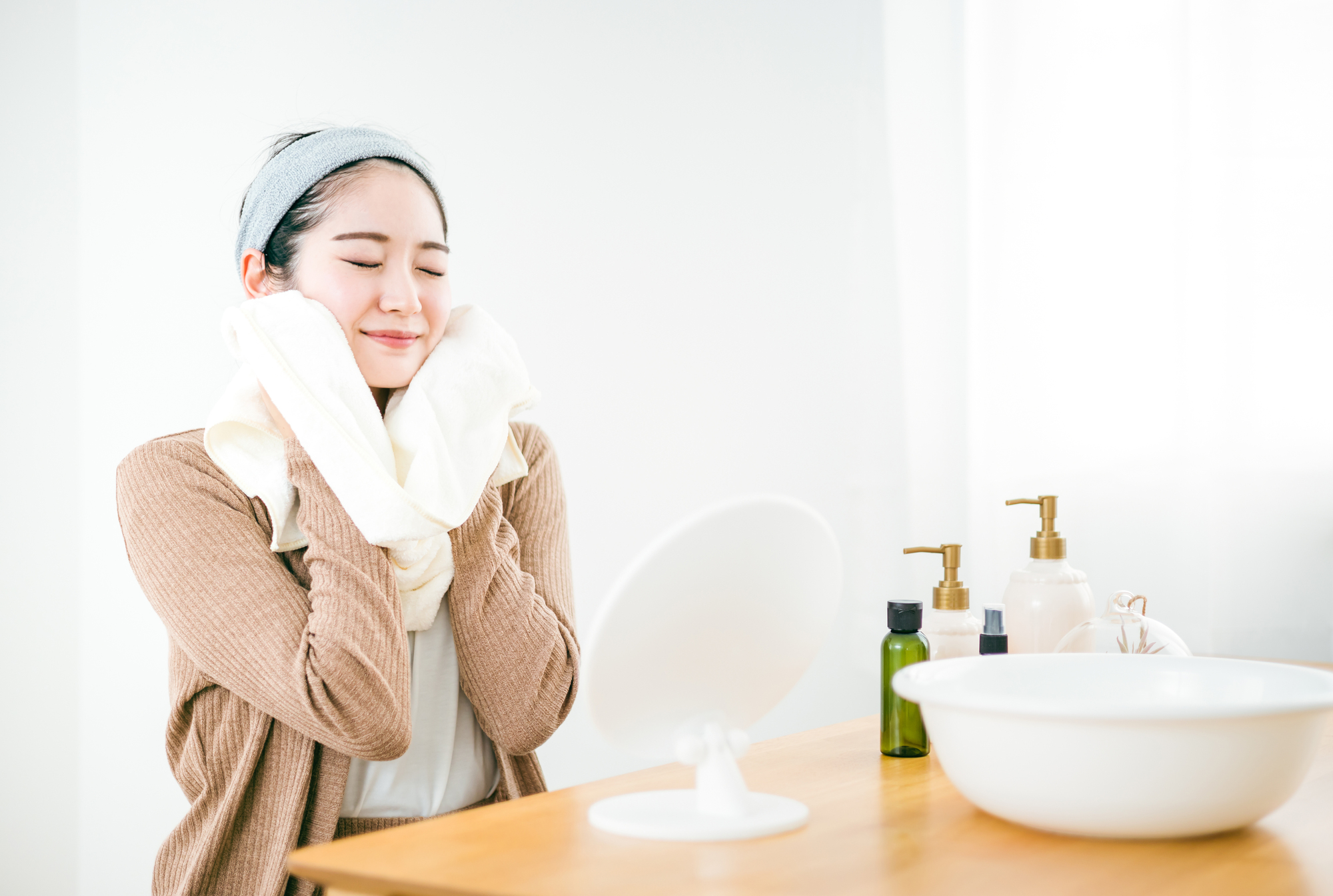 洗顔後タオルドライする女性