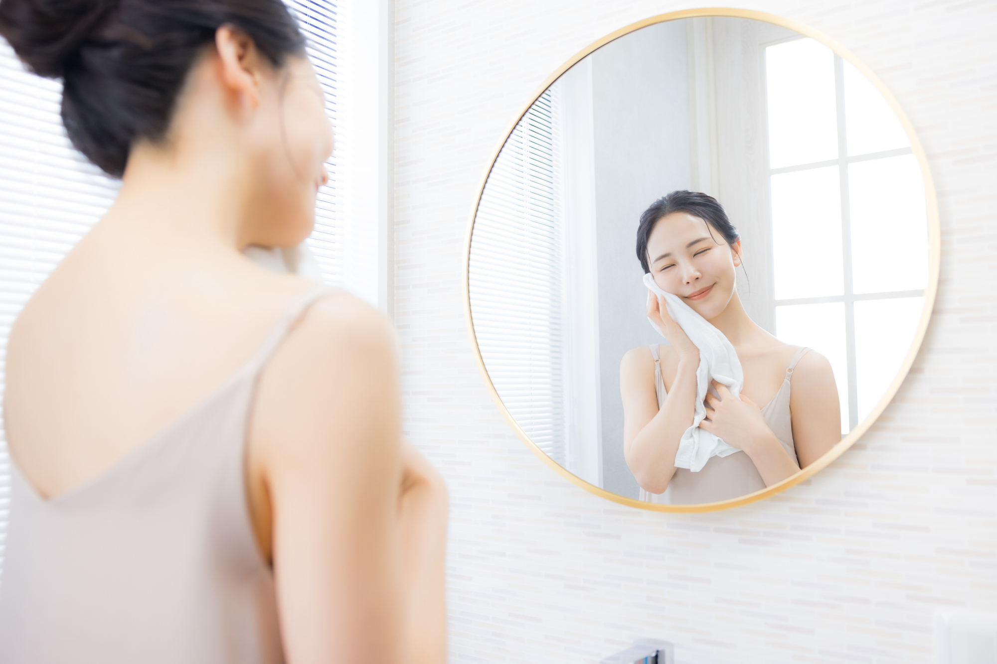 タオルで顔を拭く女性