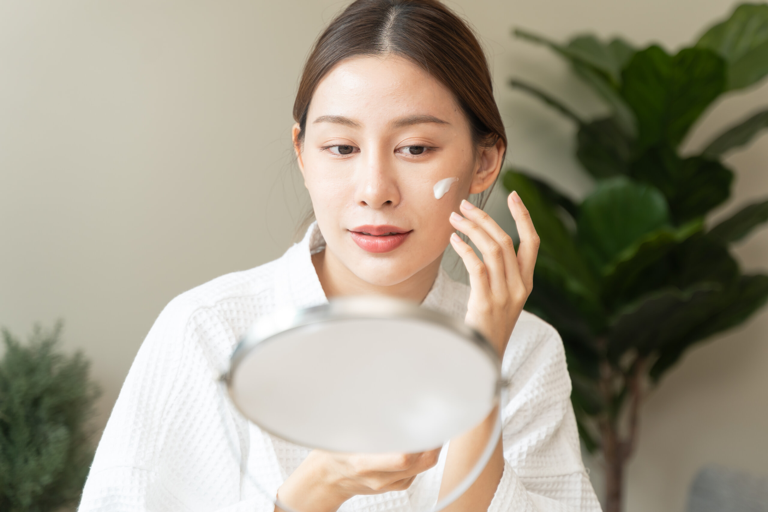 顔に日焼け止めを塗る女性