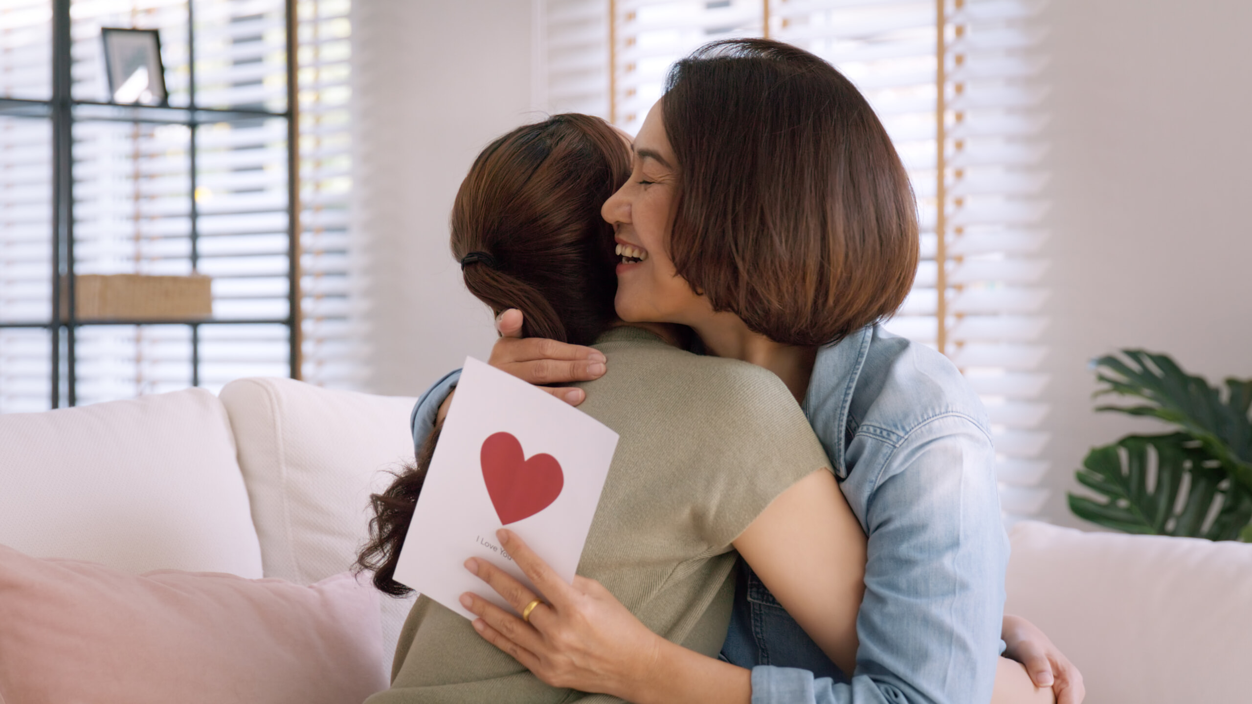 嬉しそうに娘をハグする母親