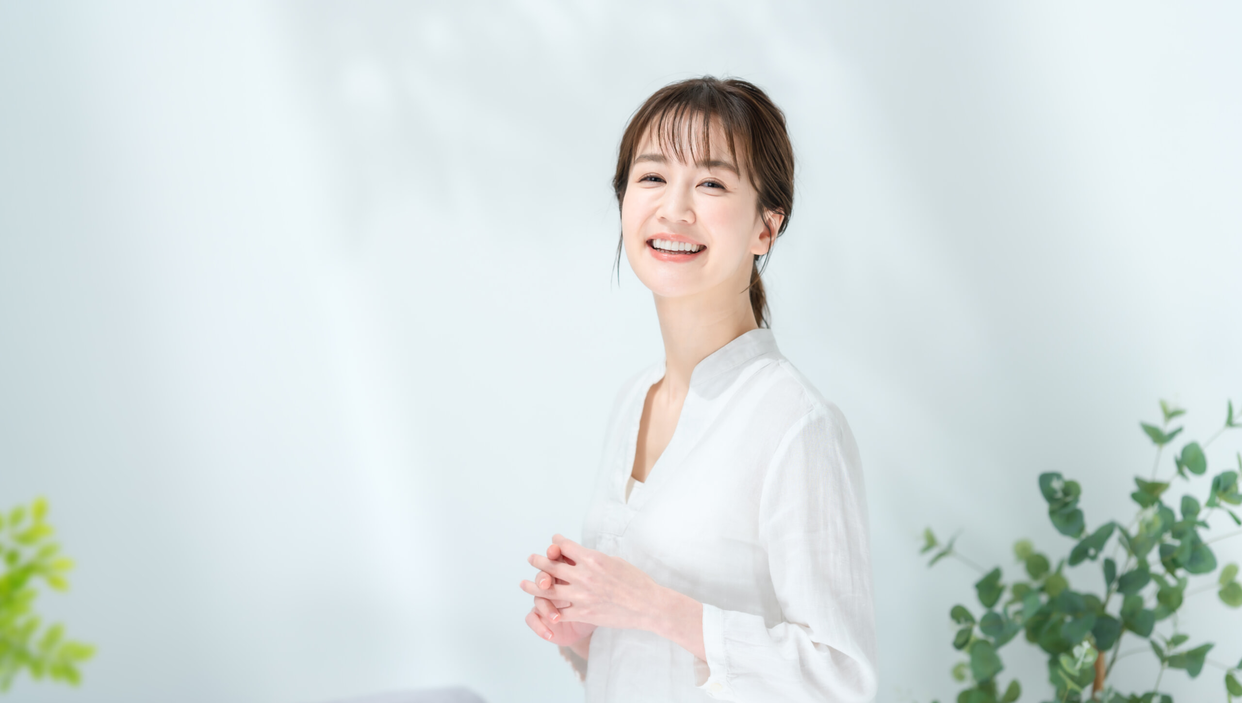 光の中でにっこり笑う、透明感のある肌の女性