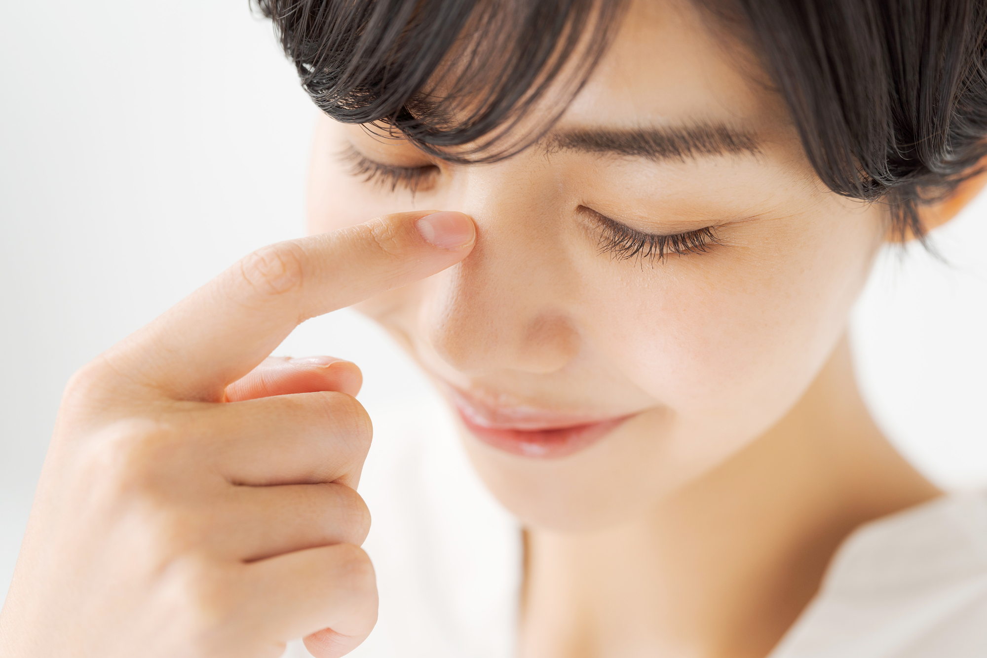 鼻を指さす女性