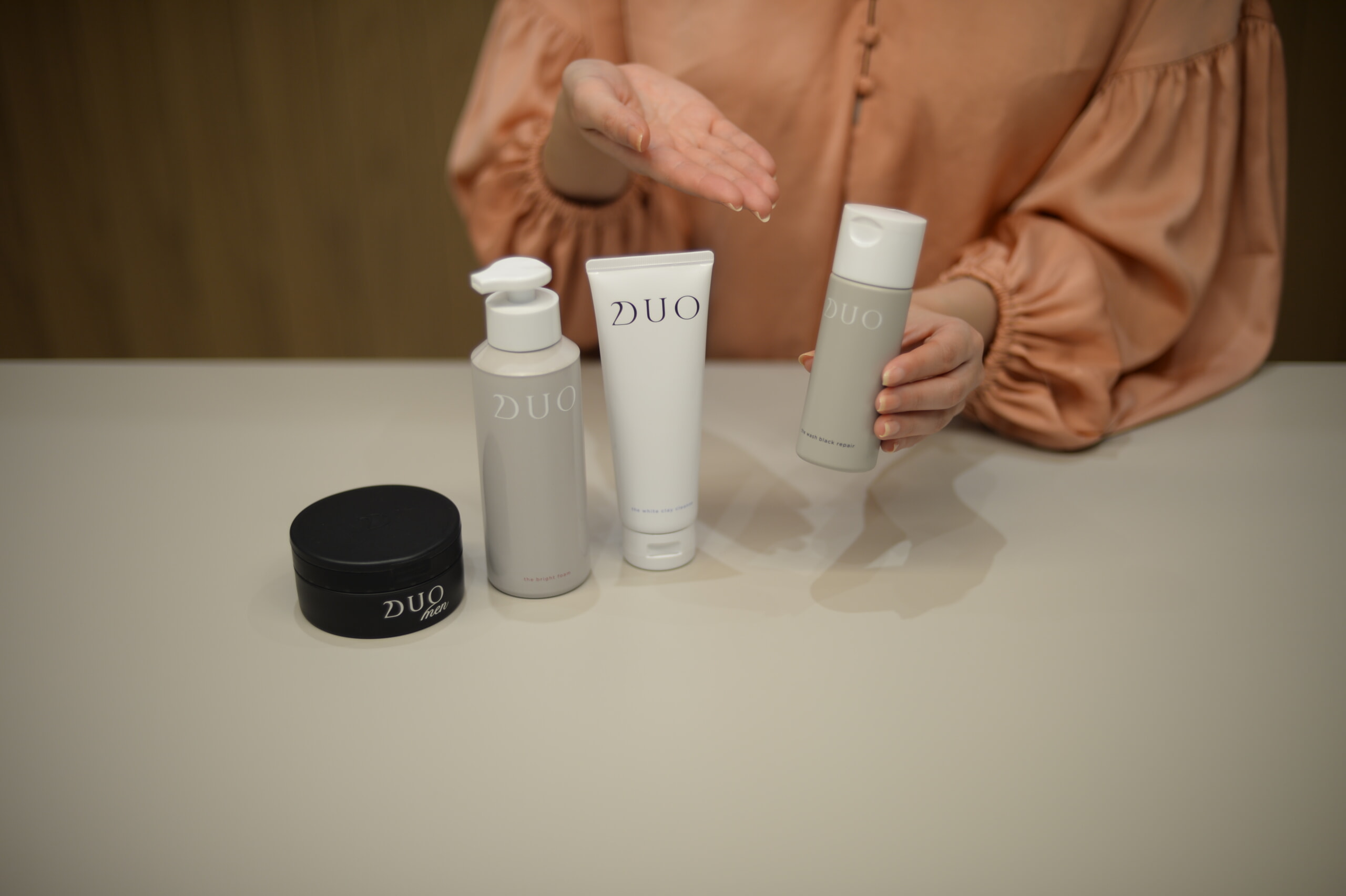 インタビュー風景_DUO ザ ウォッシュ ブラックリペアを手に持つ商品企画開発担当者