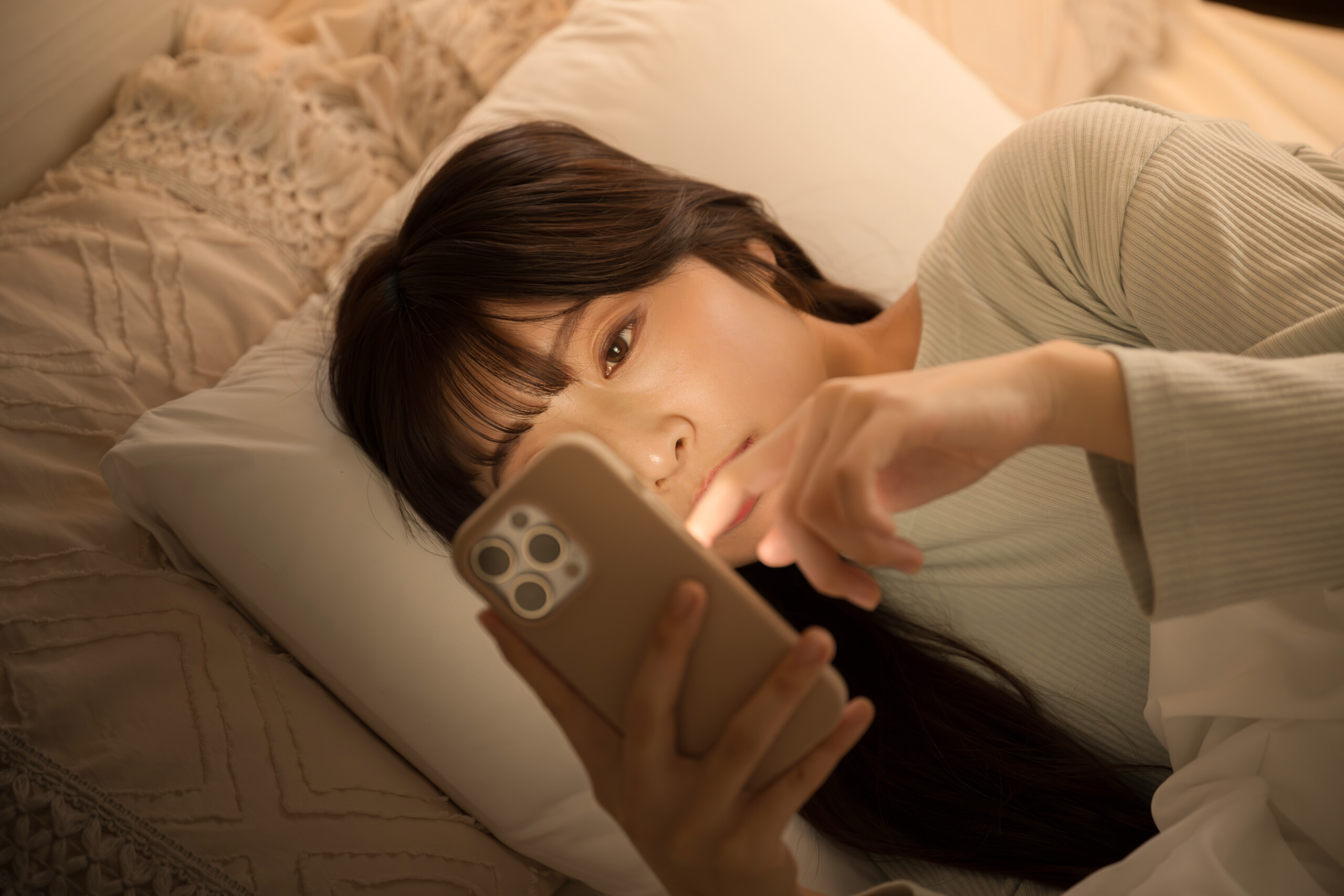 夜中にスマホを操作する女性