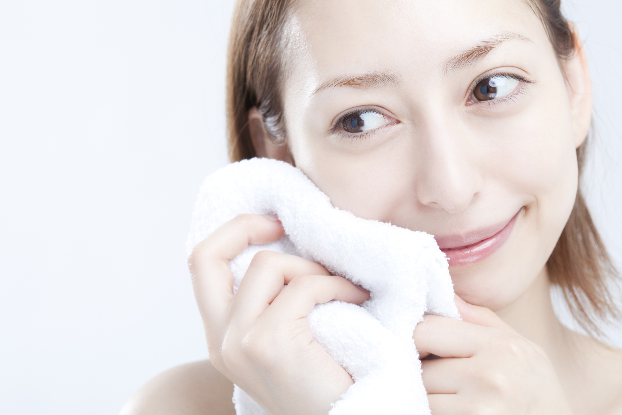 タオルで顔を拭く女性