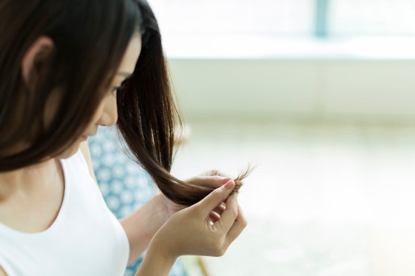 毛先を見つめる女性