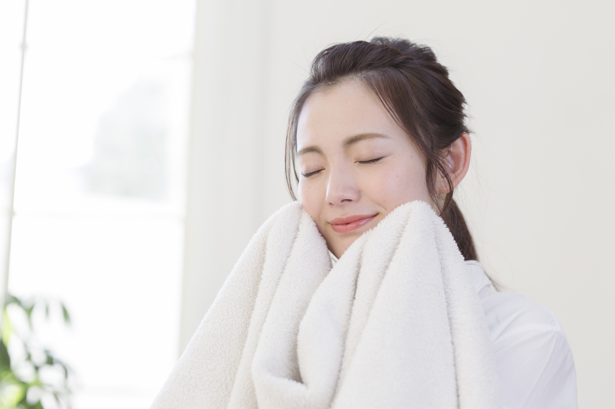 タオルで顔を拭く女性