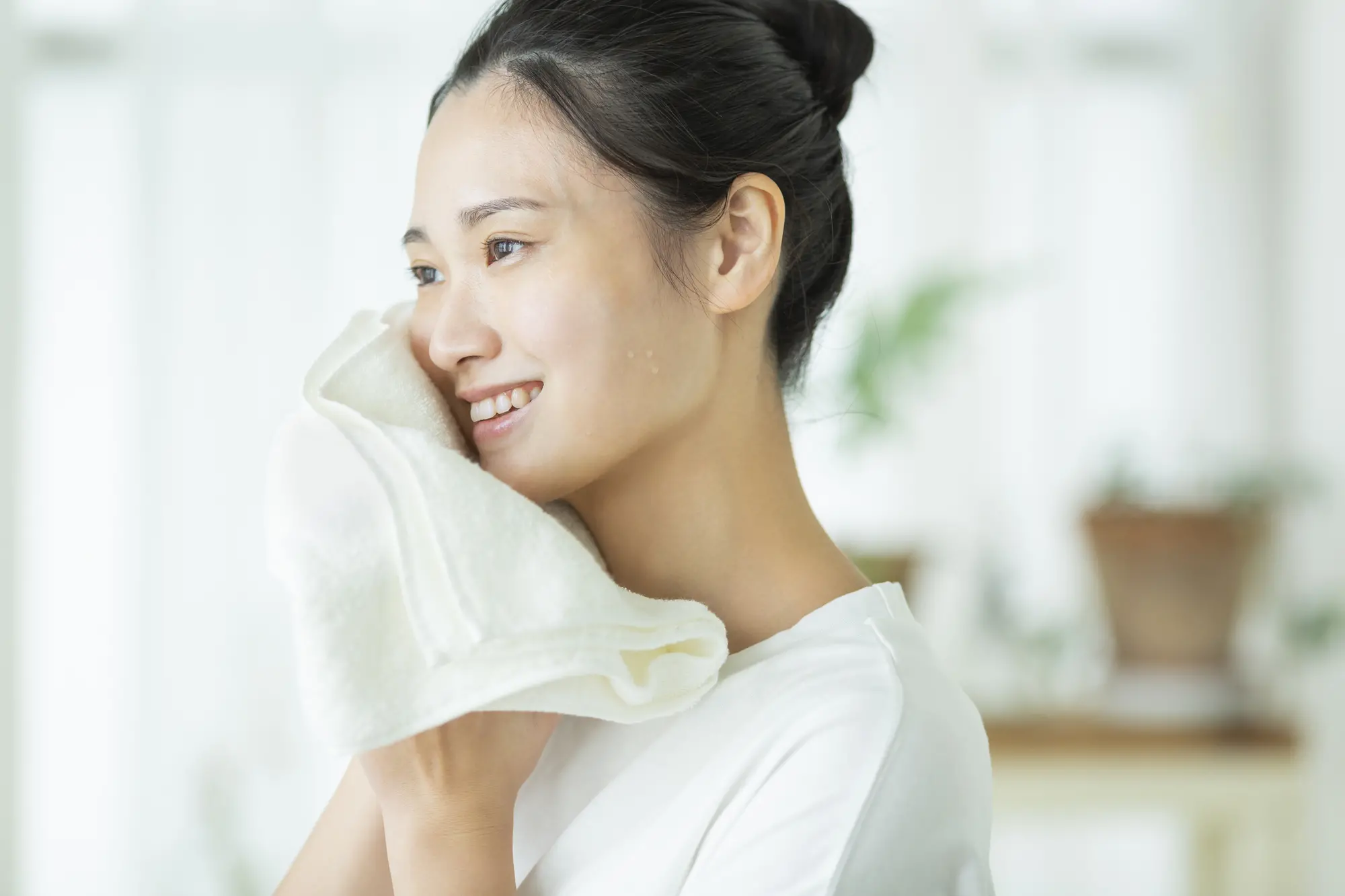 タオルで顔を拭く女性