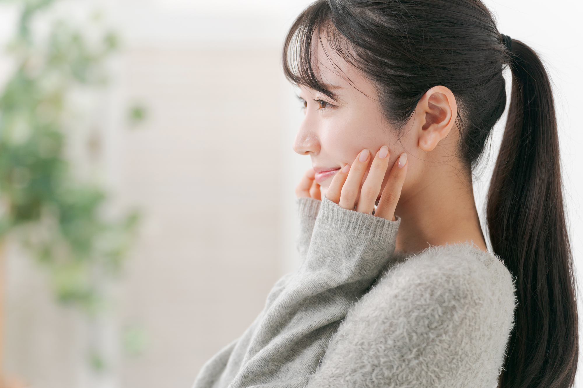 頬に手を当て微笑む女性