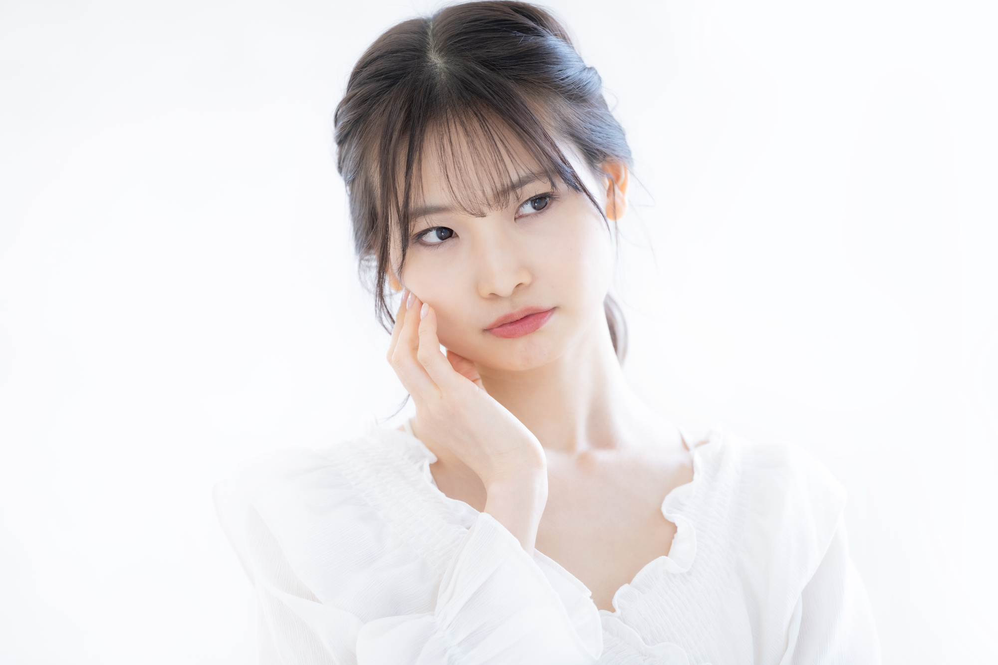 頬に手を当て首をかしげる女性