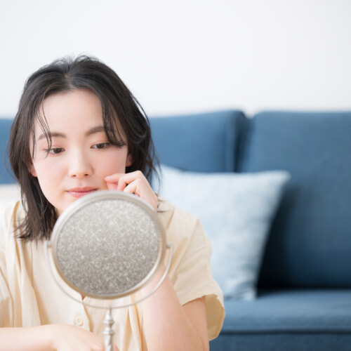 鏡でお肌のチェックする女性
