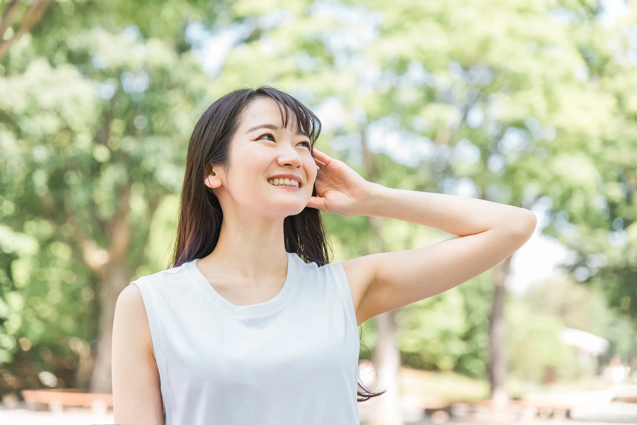 Chất liệu hình ảnh_Một người phụ nữ tươi tắn đang vén tóc ra sau tai giữa thảm thực vật xanh tươi