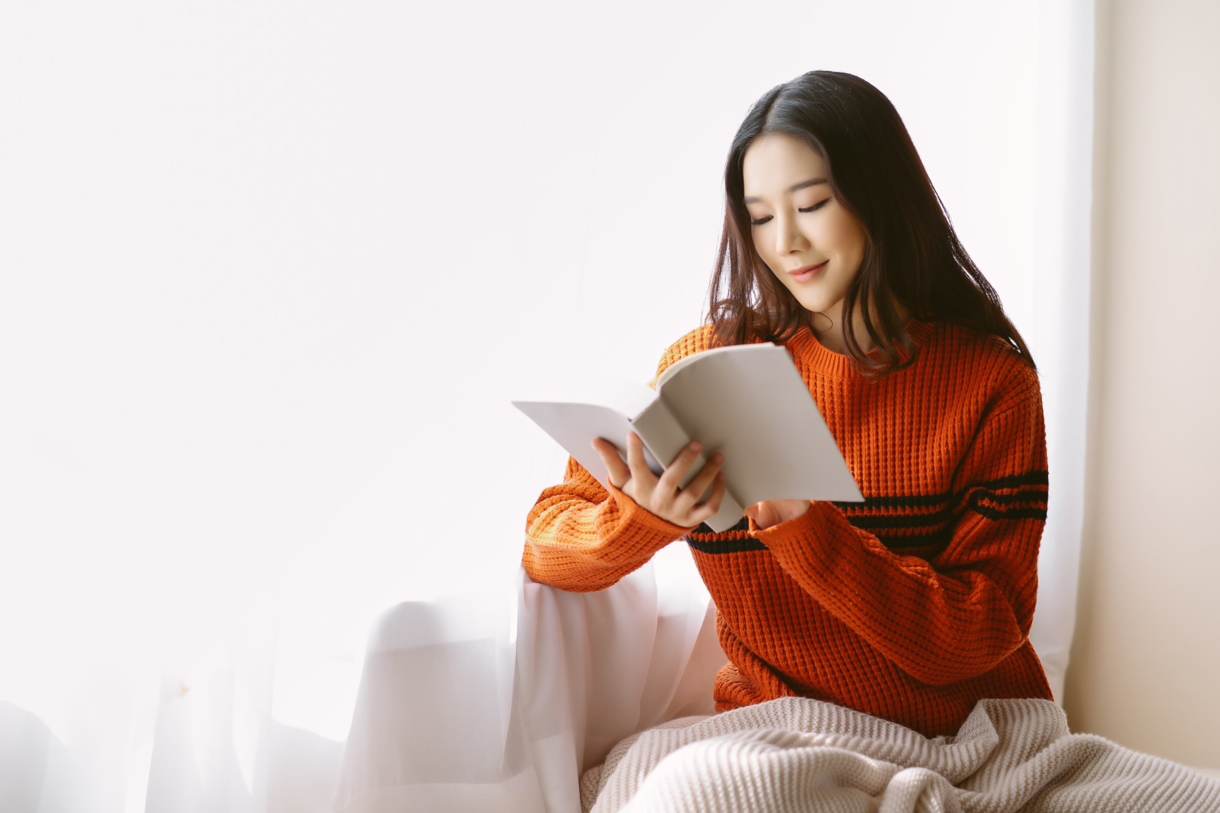 窓辺で読書する女性