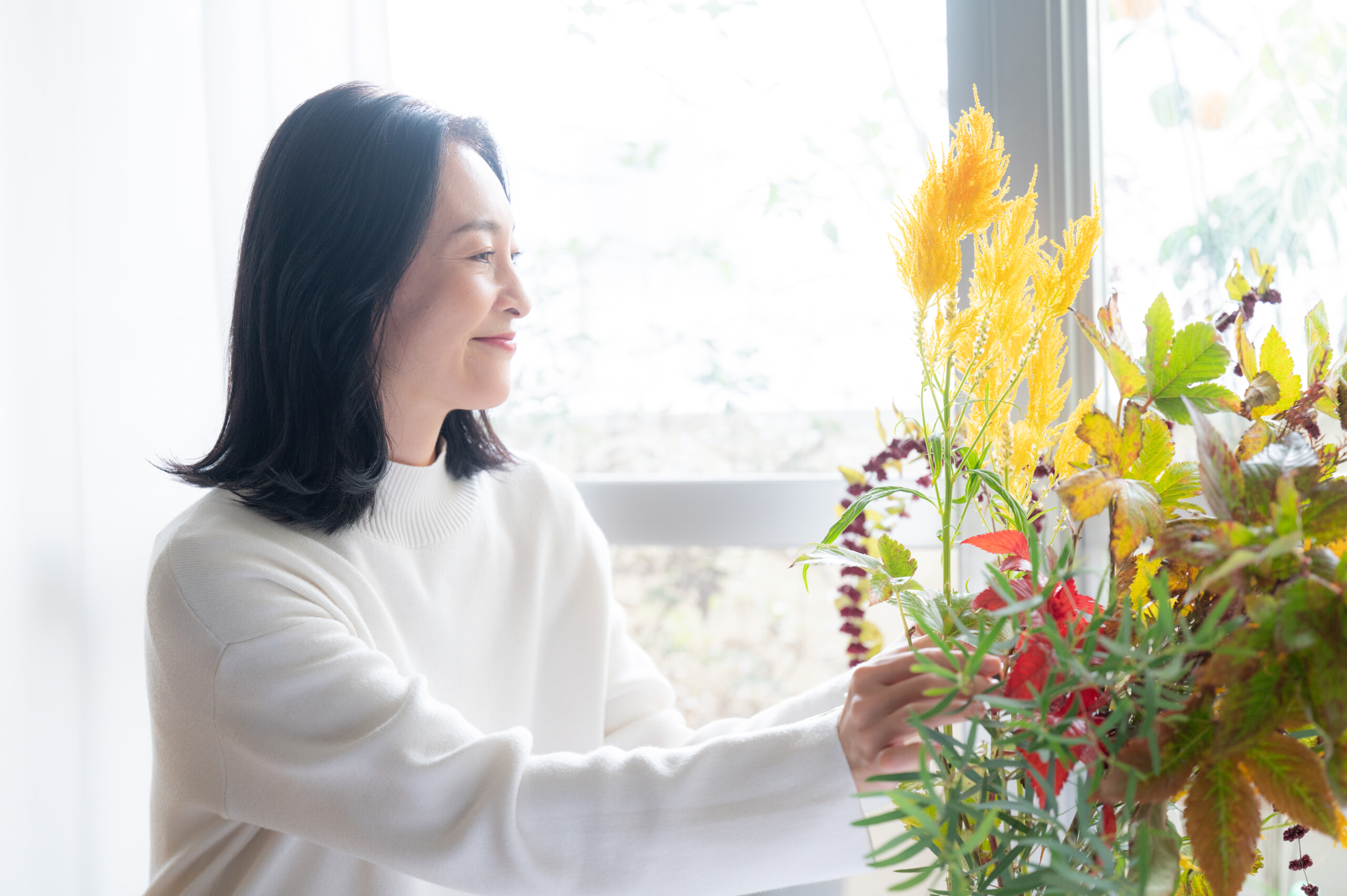 生け花を楽しむ健やかな肌の女性