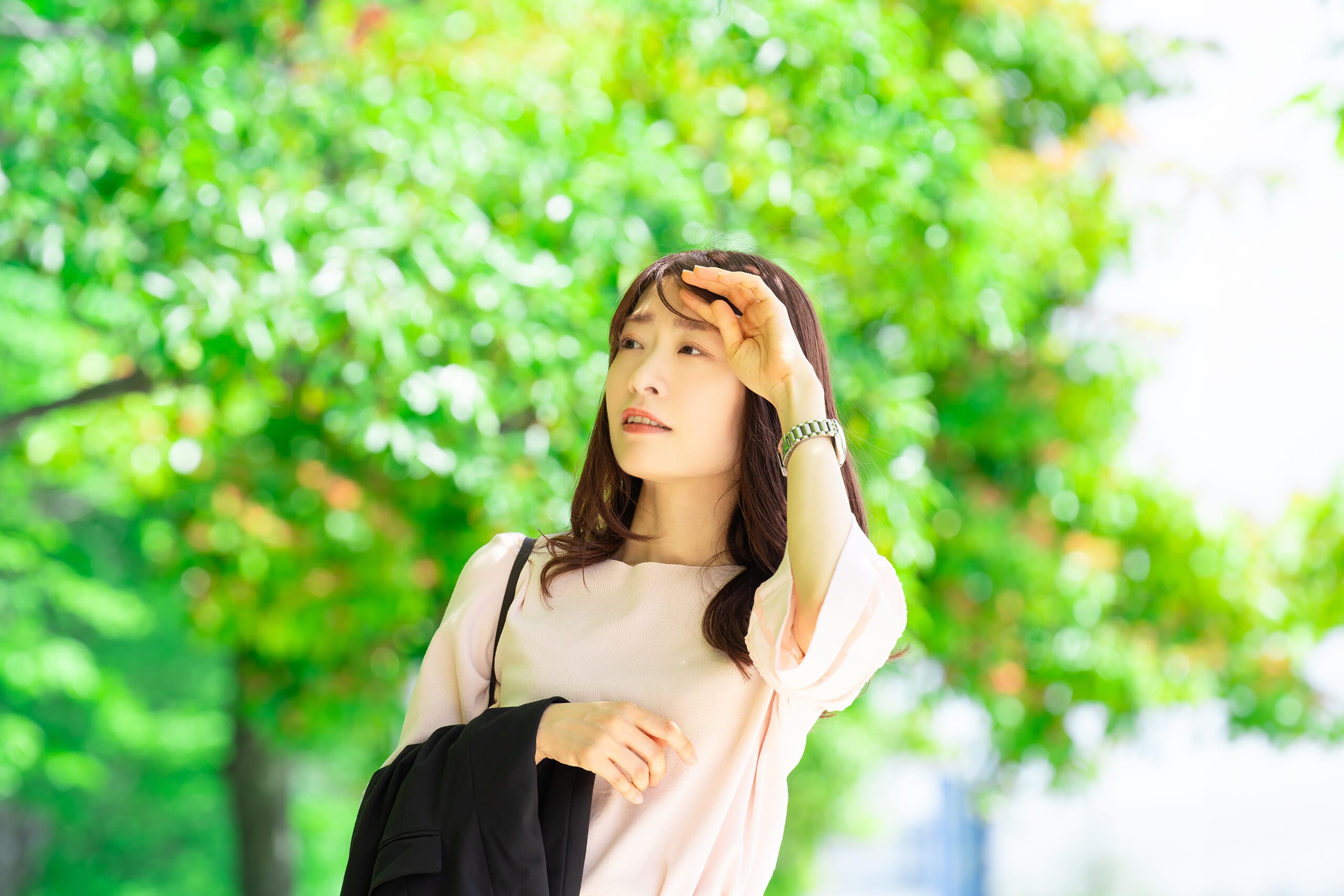 汗を拭いながら外を歩く女性