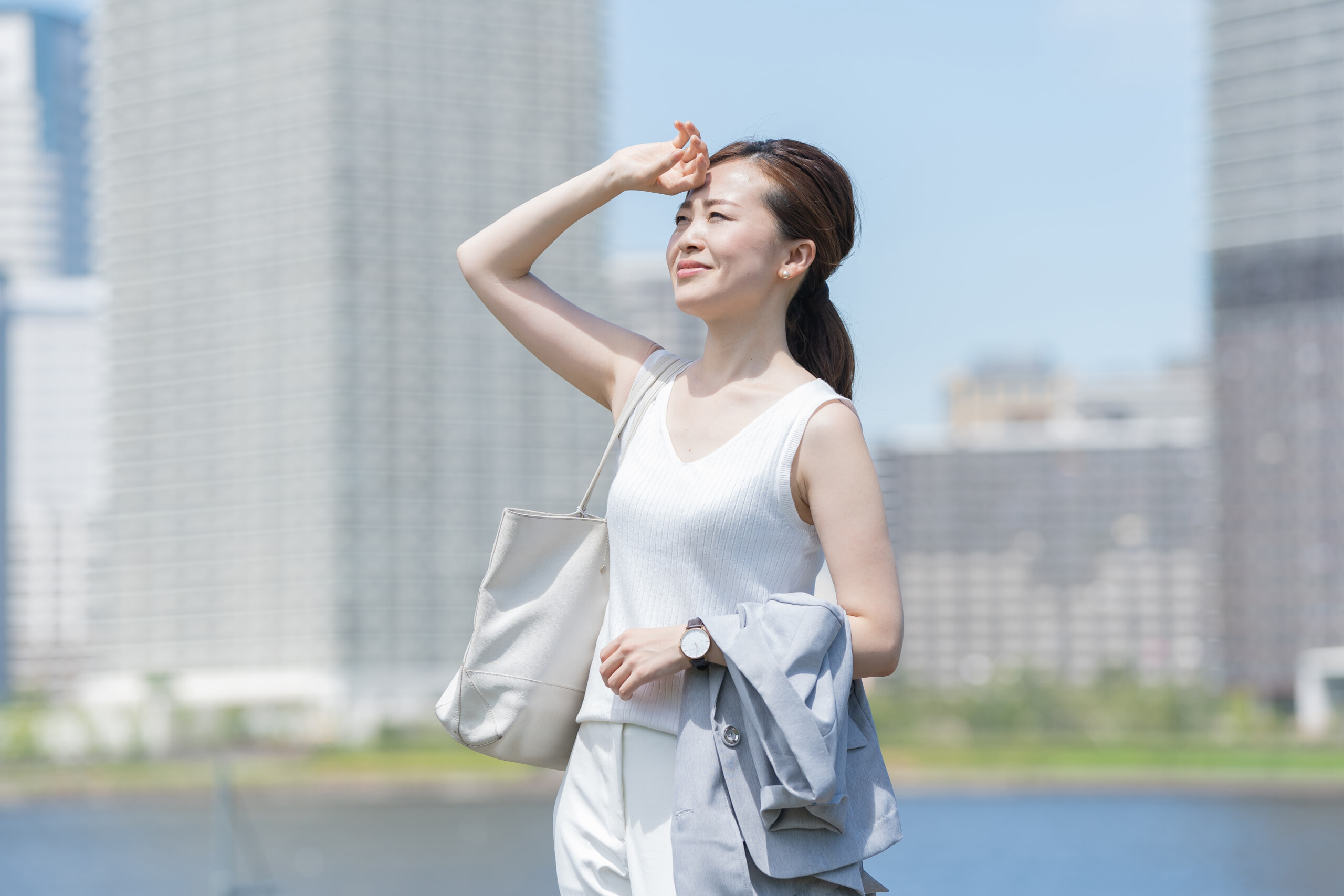 汗を拭いながら外を歩く女性
