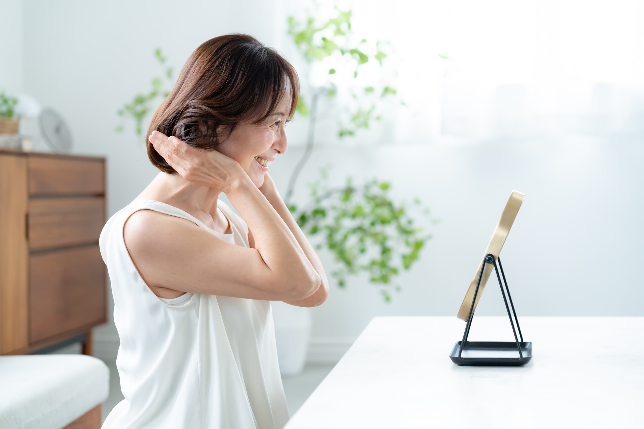 鏡で髪型をチェックする女性