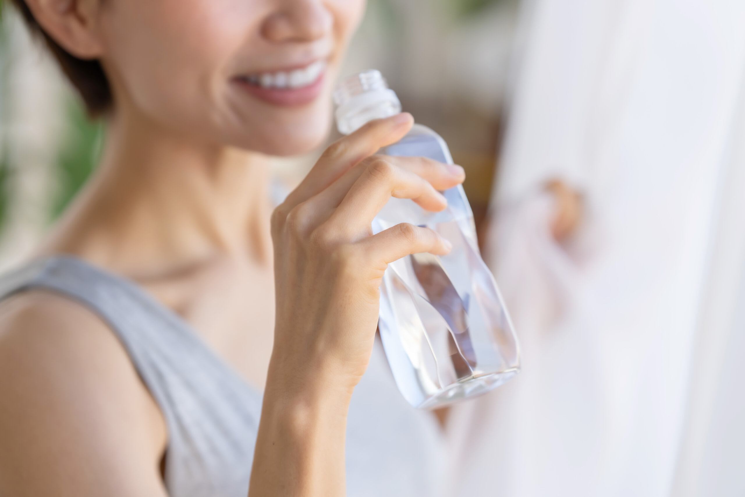 ペットボトルの水を飲む女性