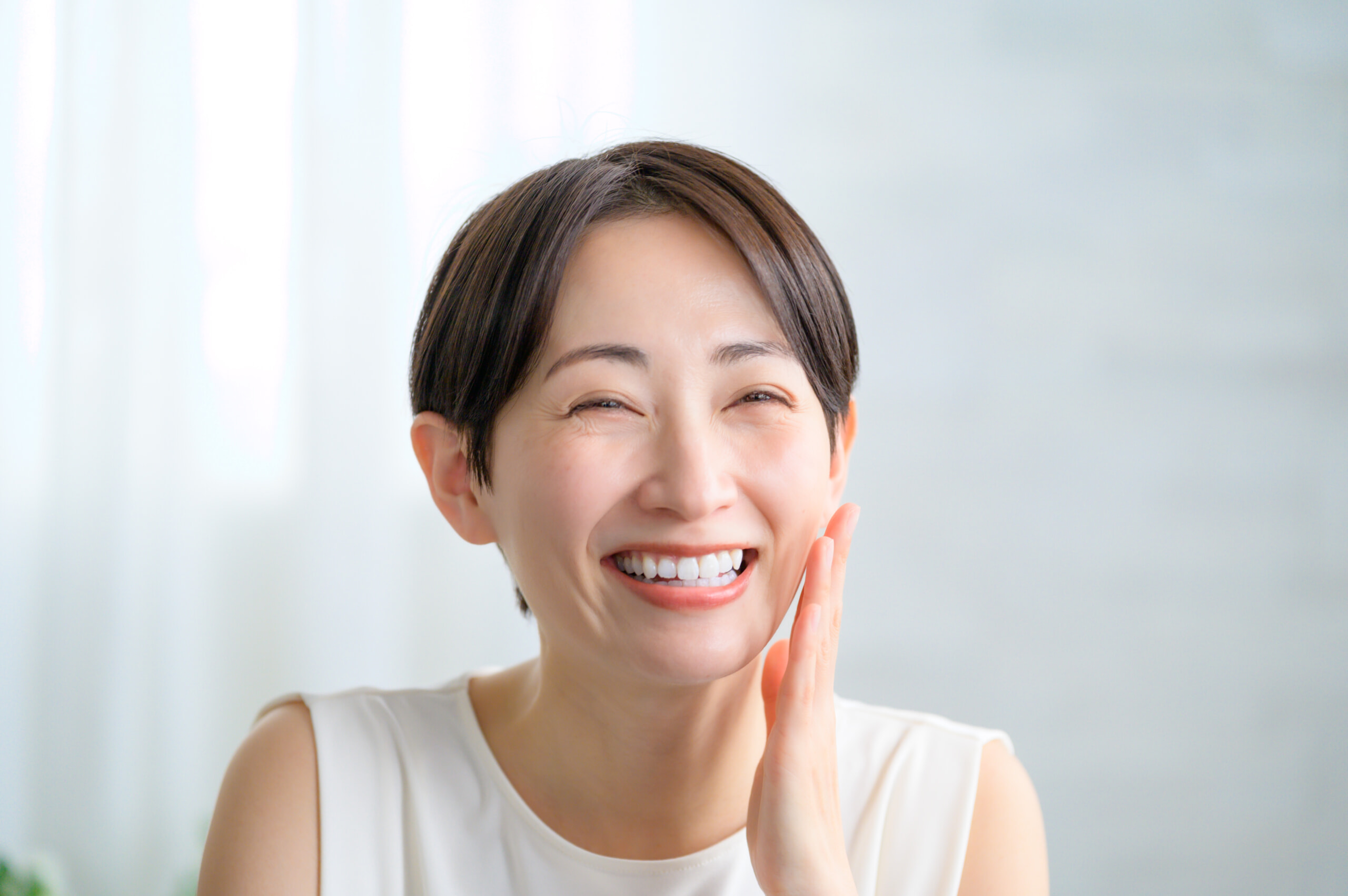 頬に手をあて微笑む女性