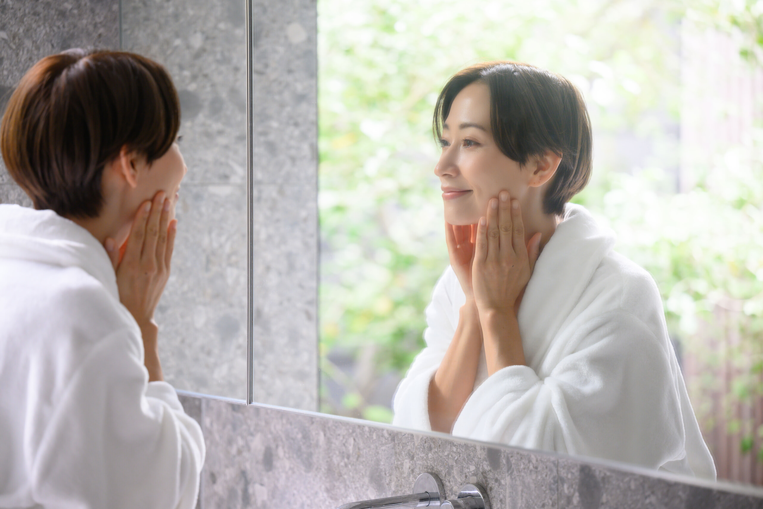 お風呂上りにスキンケアする女性