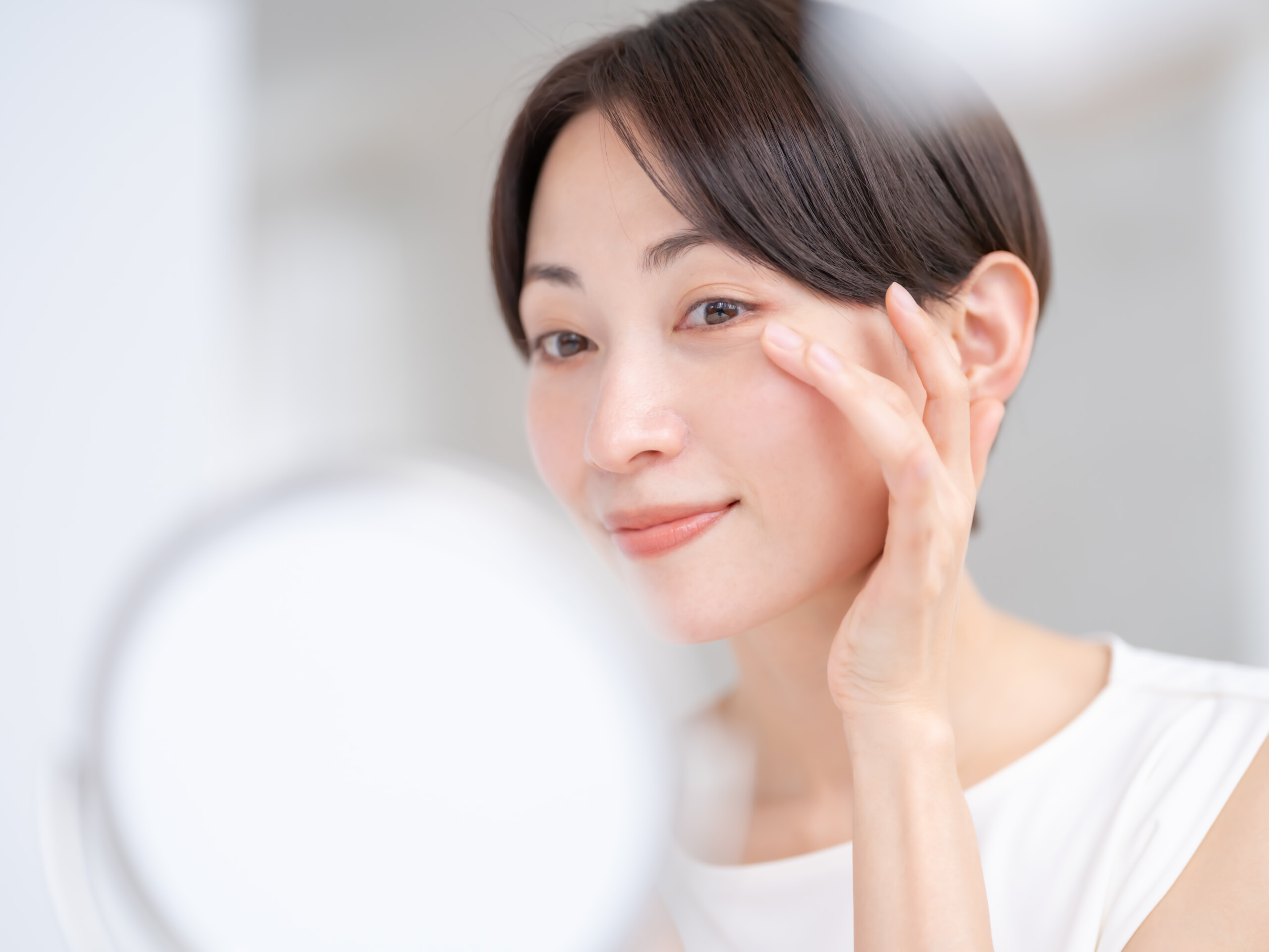 鏡を覗く美肌の女性