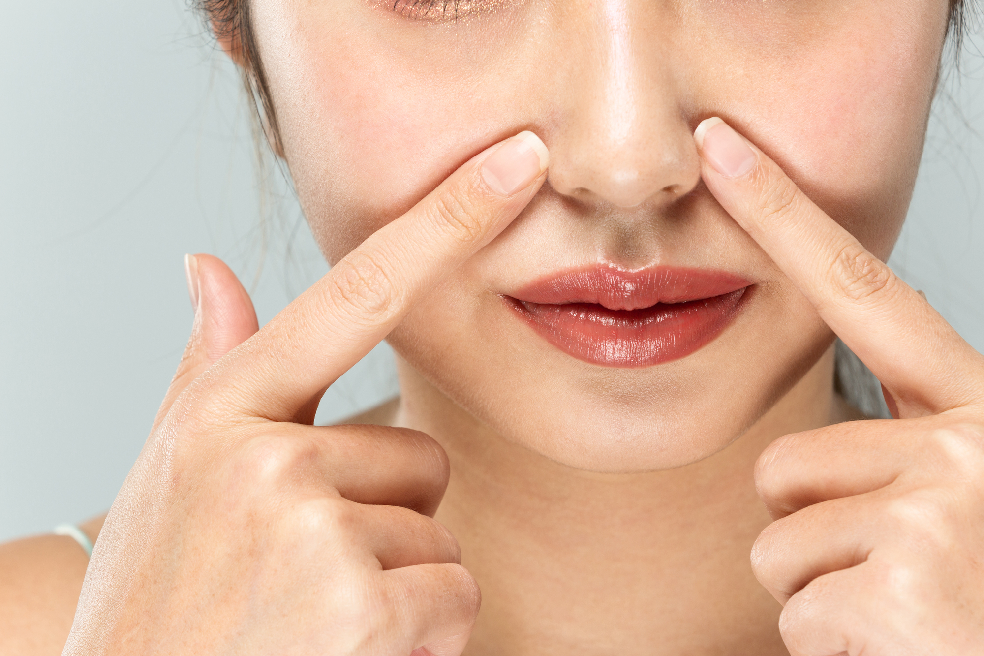 小鼻を指さす女性