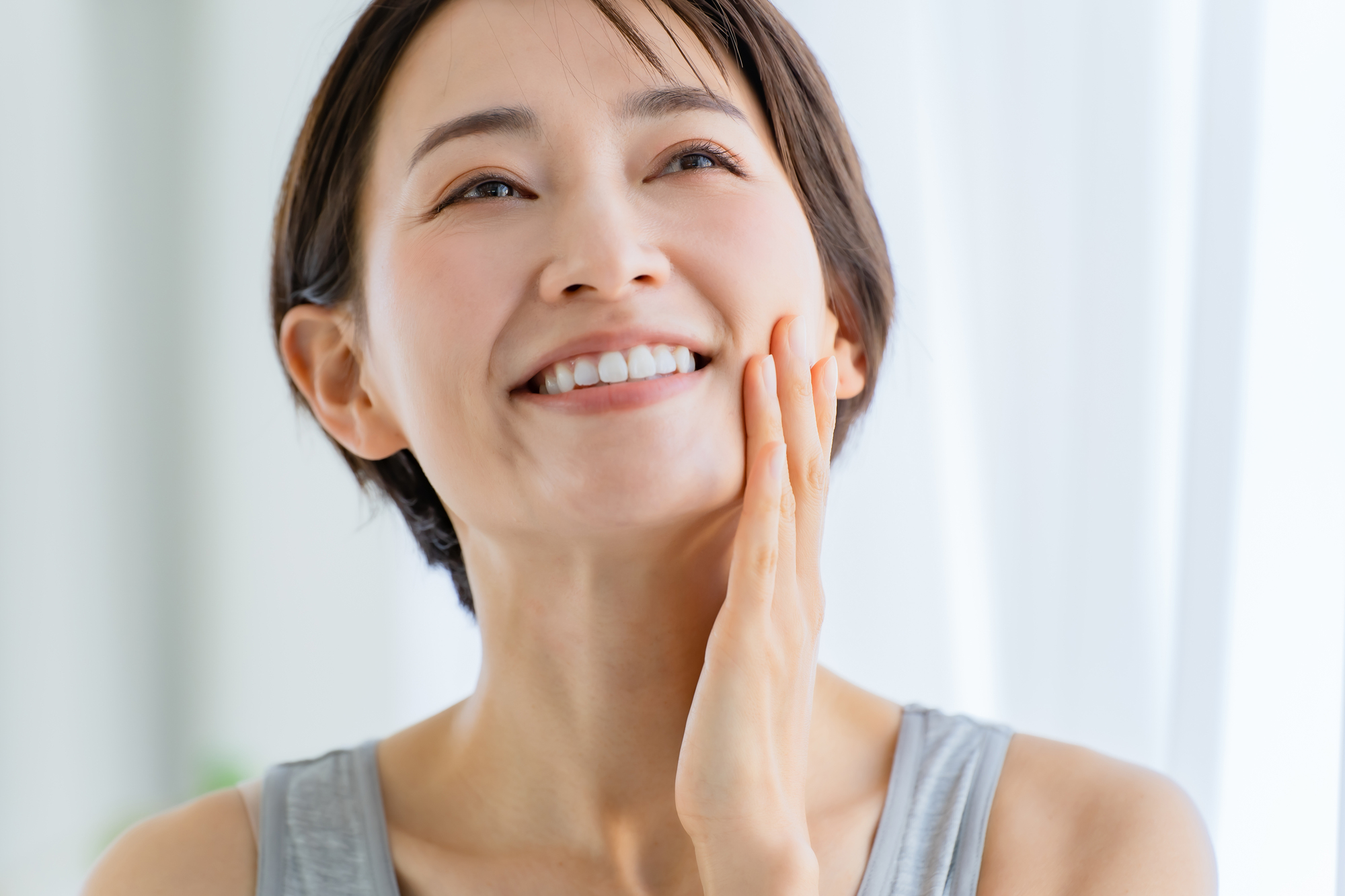 頬に手をあてにっこりする女性