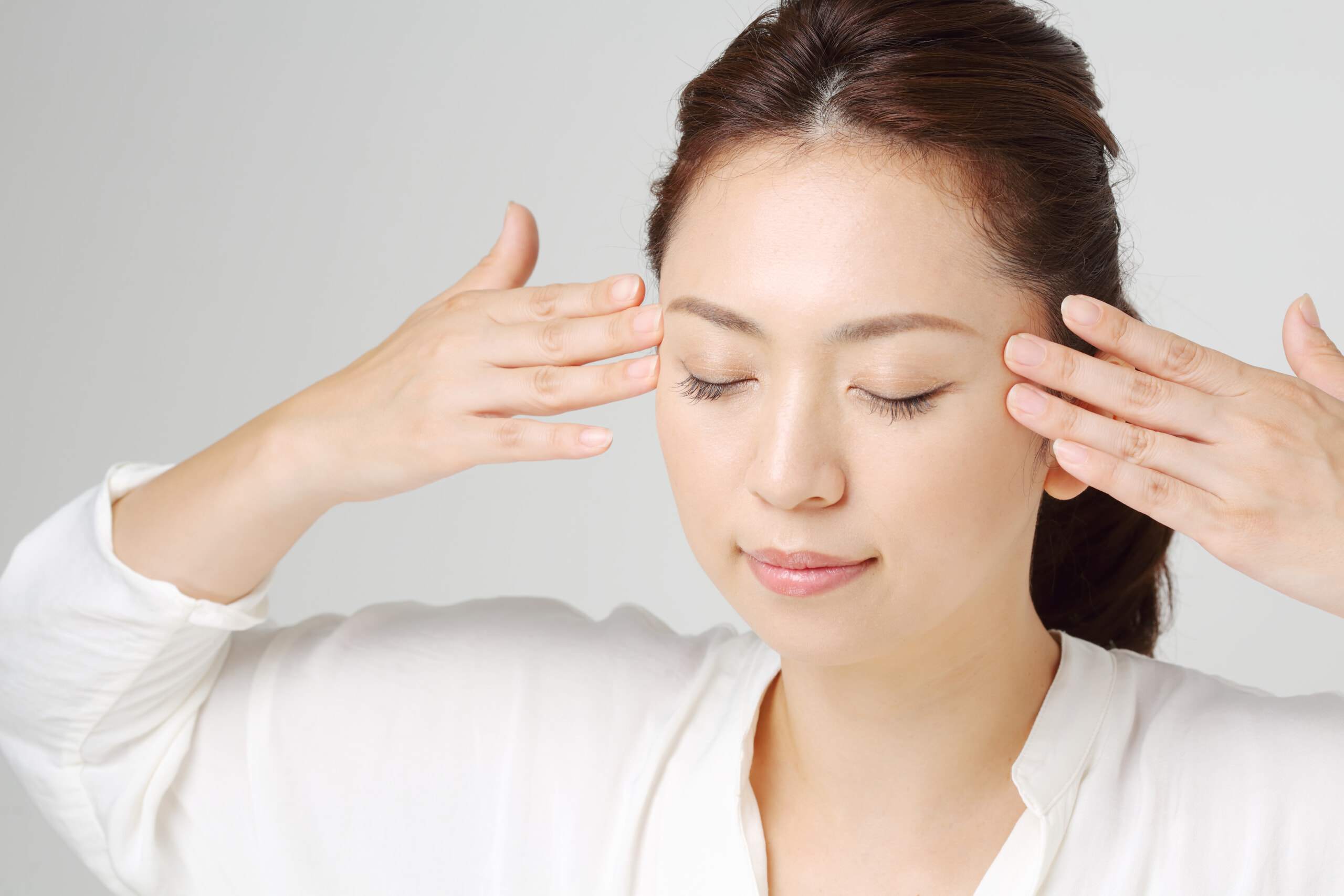 目元をマッサージする女性