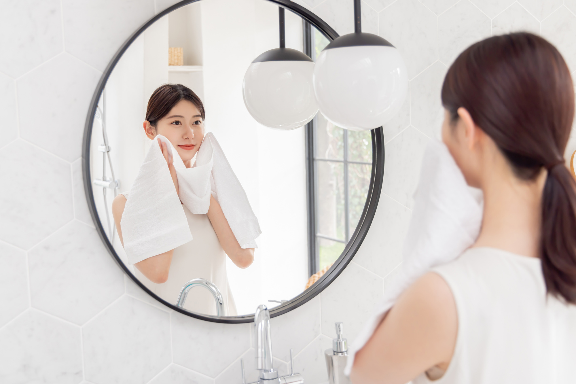 洗顔後にタオルで顔を拭く女性