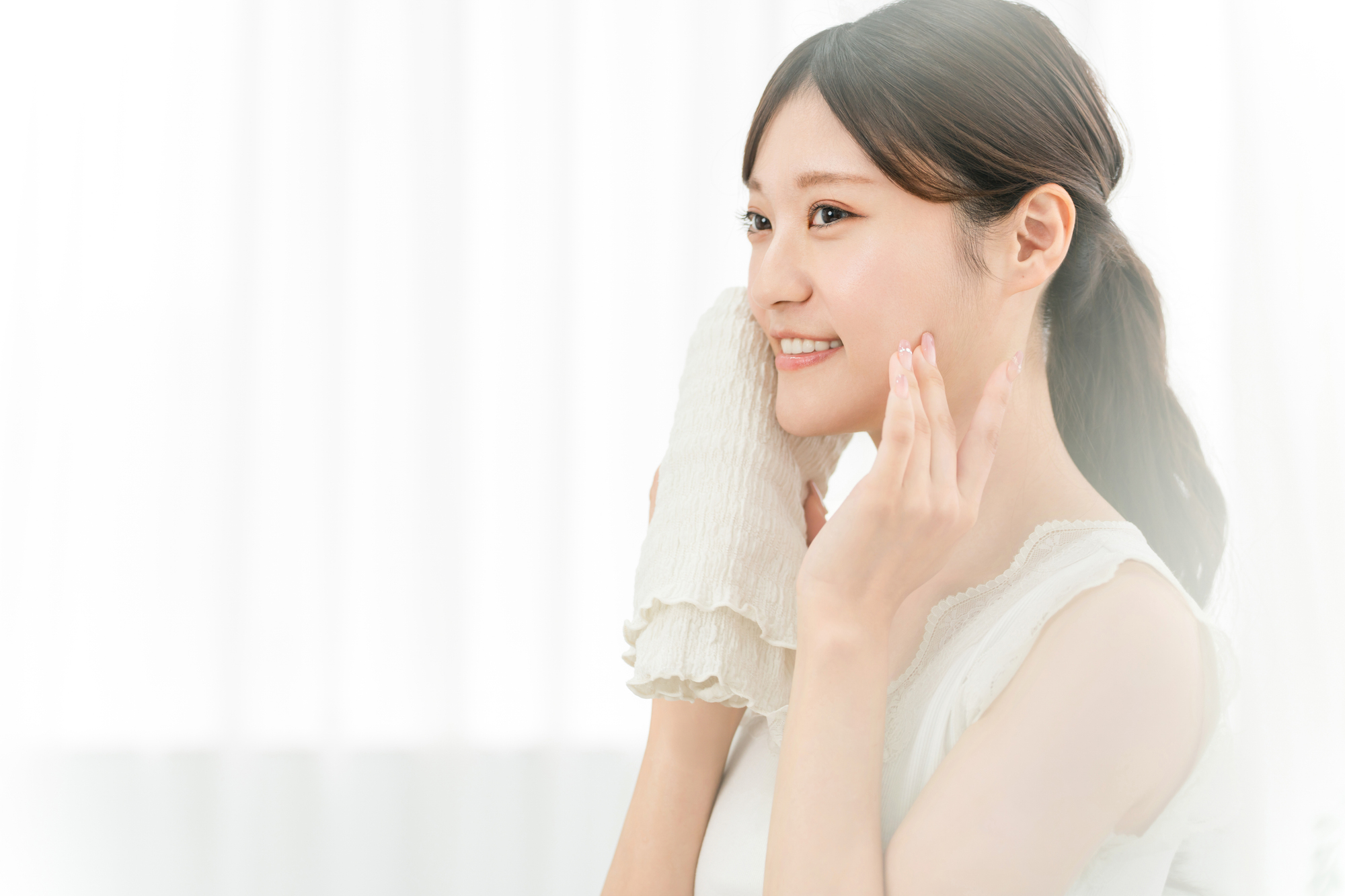 タオルで顔を拭く女性