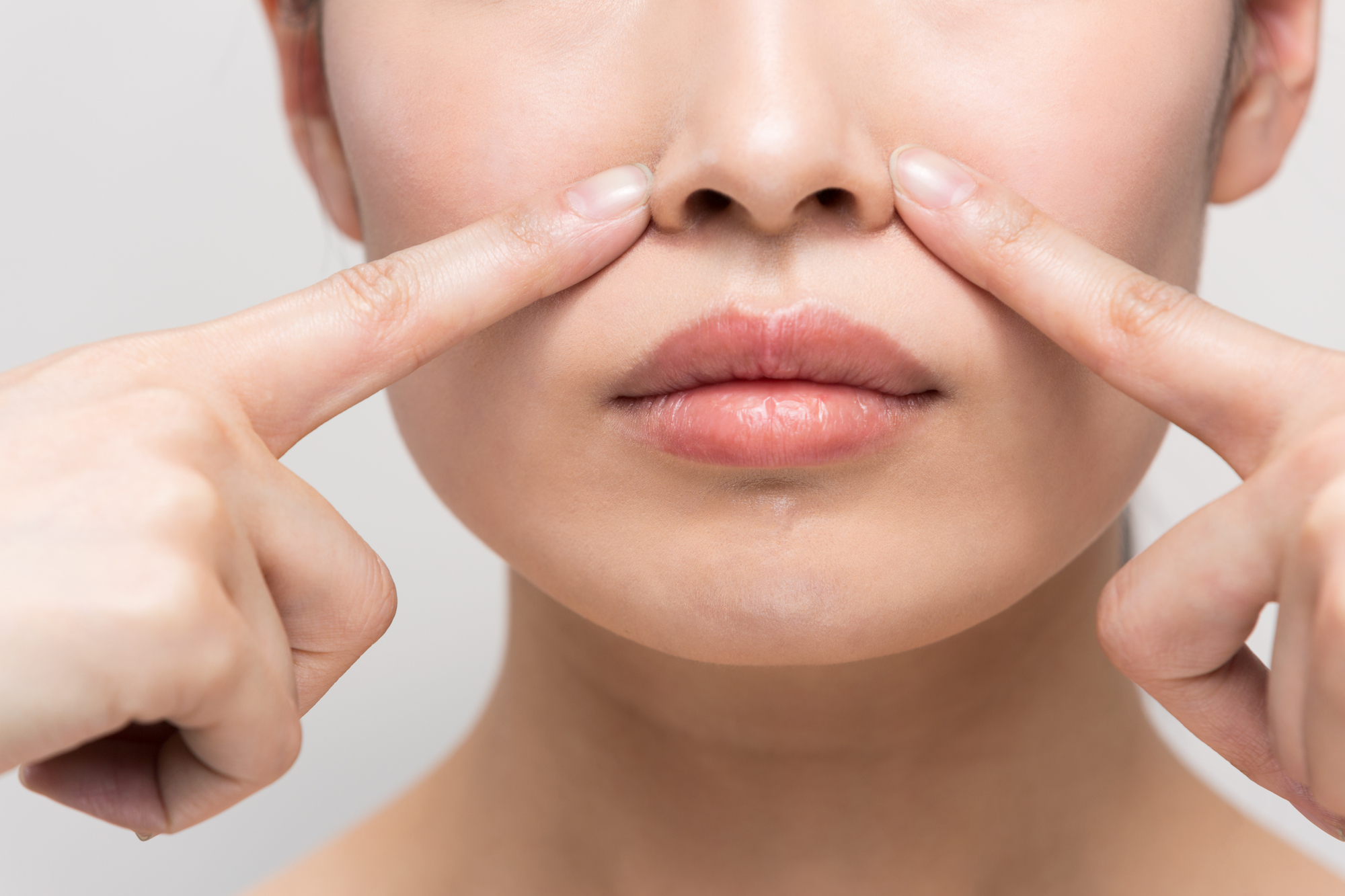 小鼻を指さす女性