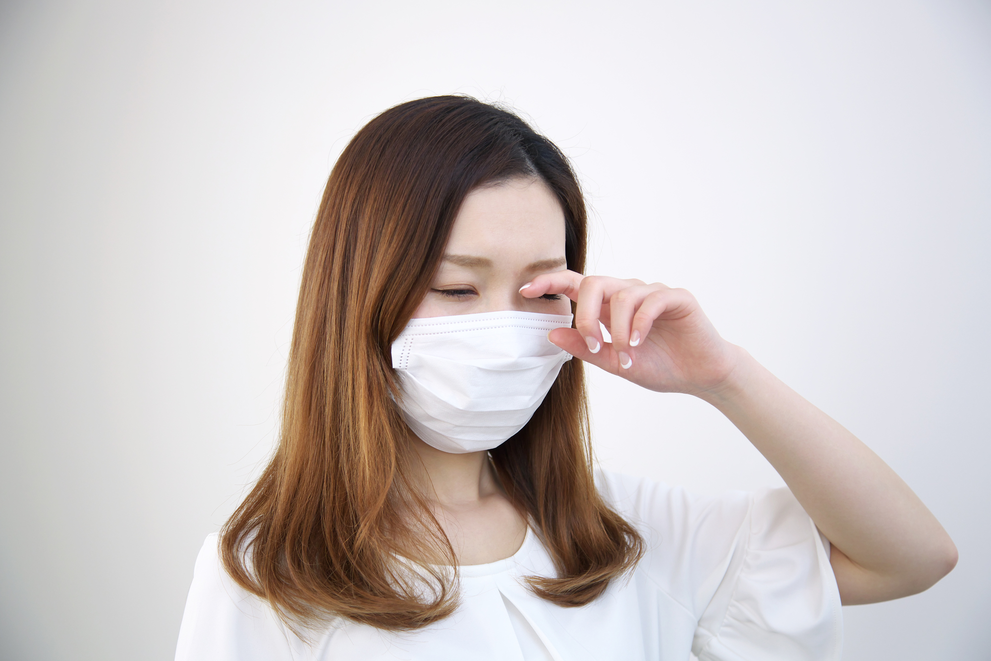 目をこする女性