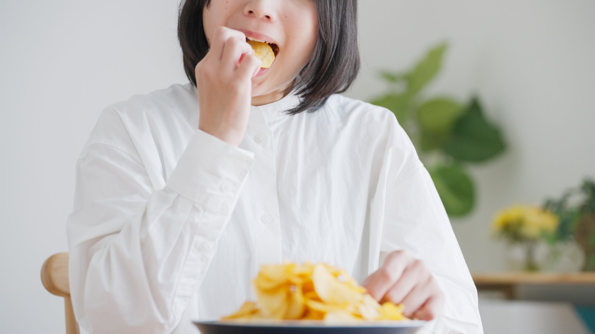 ポテトチップスを食べる女性