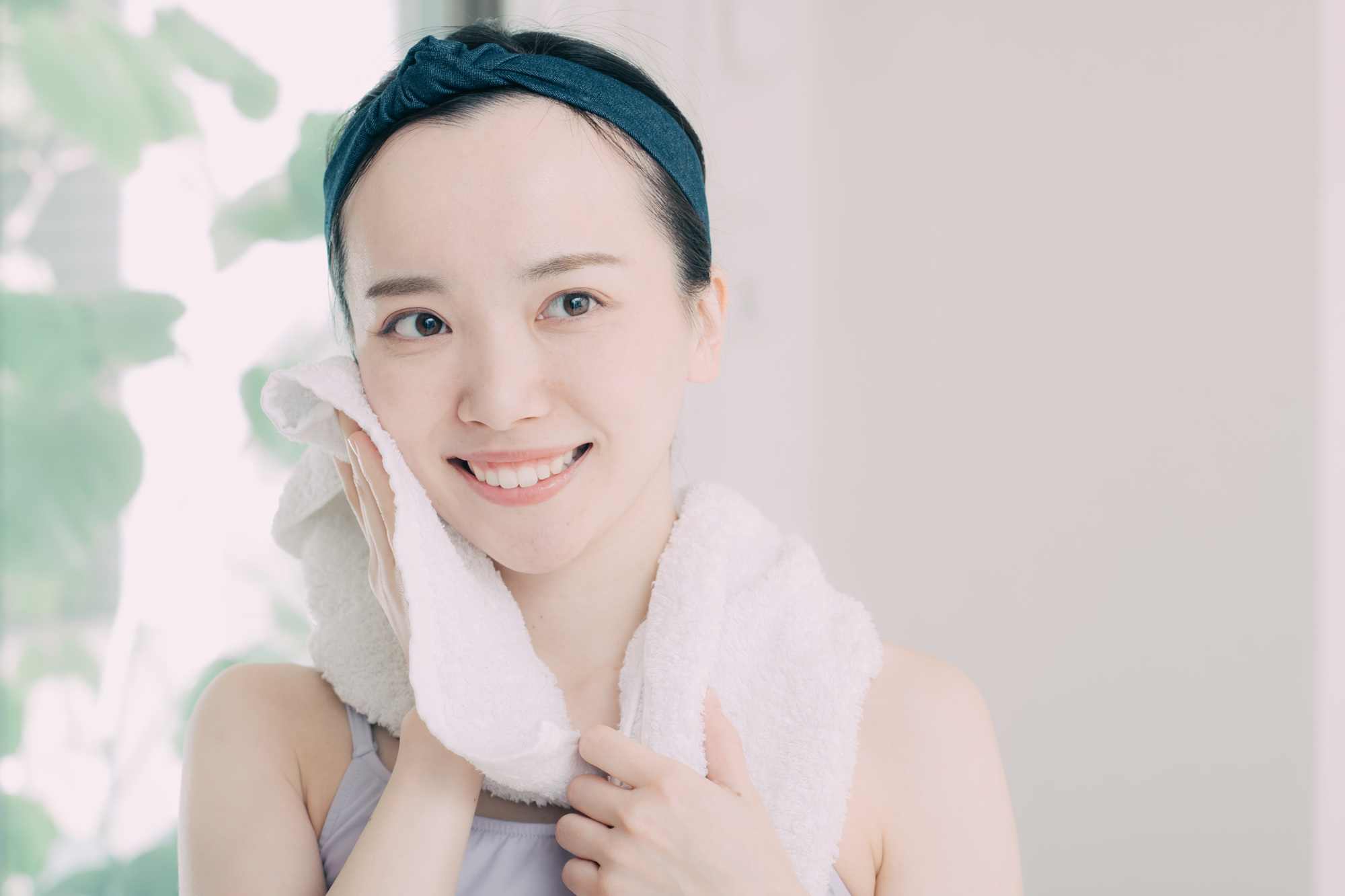 タオルで顔を拭く女性
