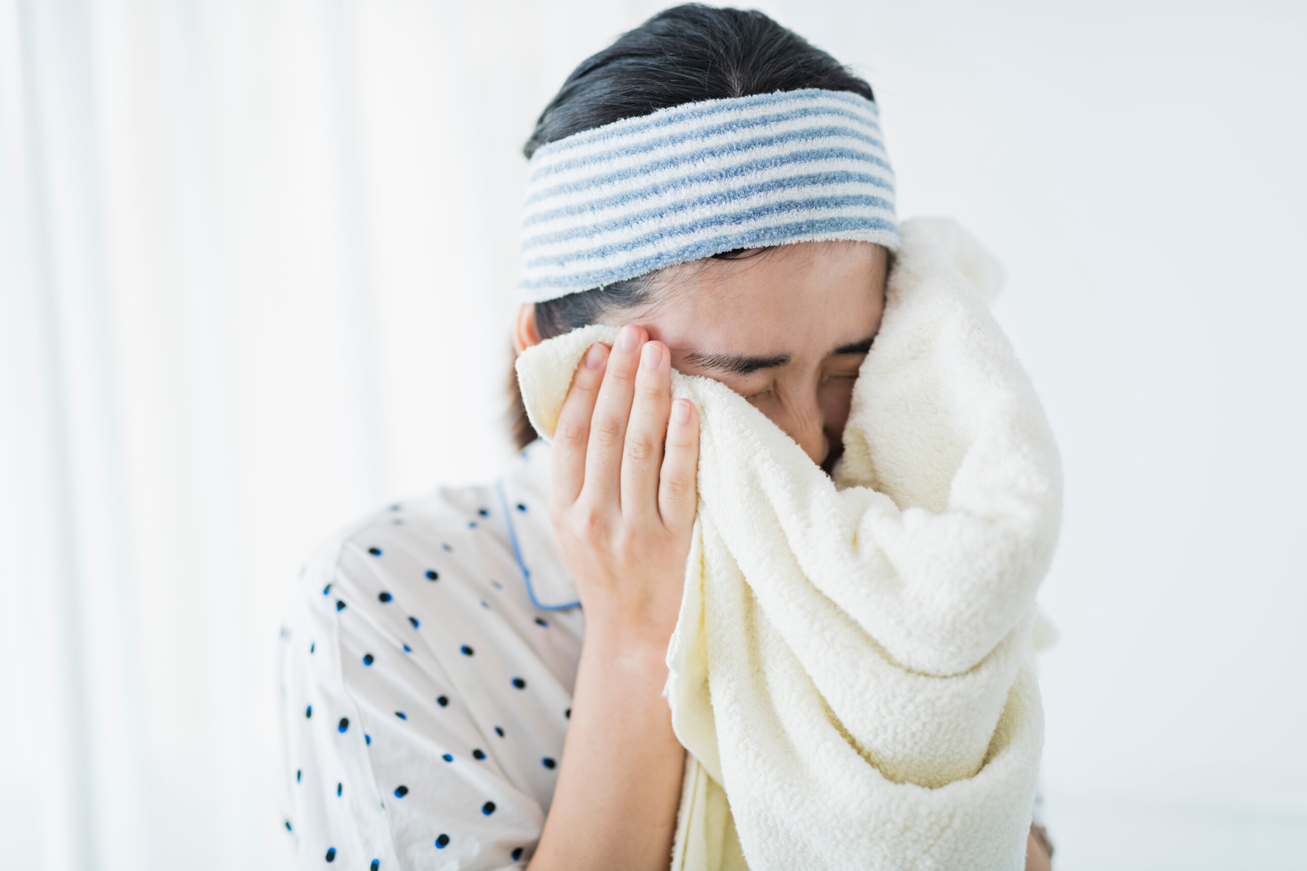 タオルで顔を拭く女性