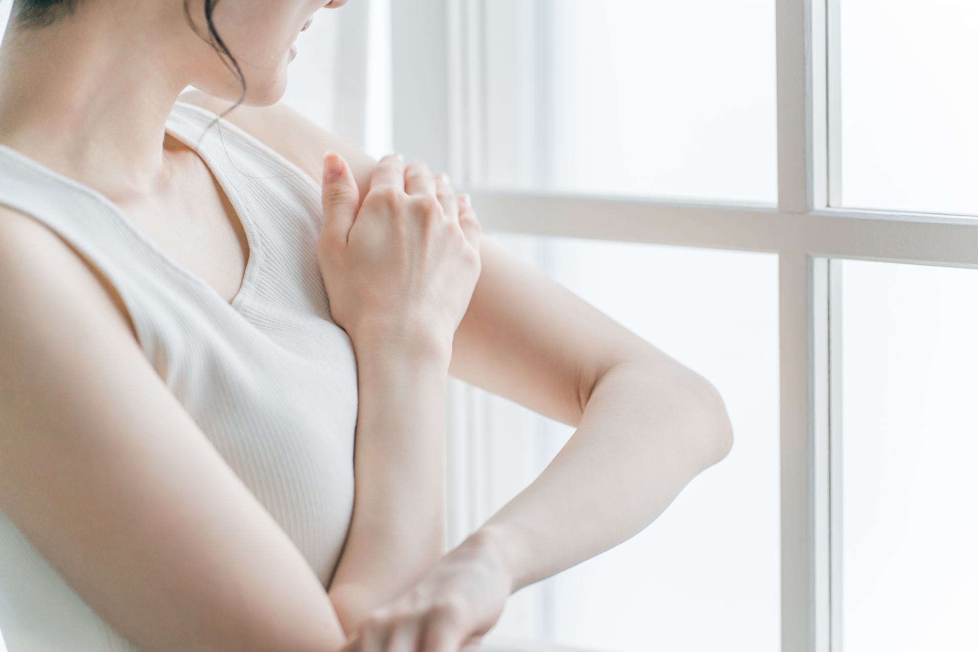 腕に手を添える女性