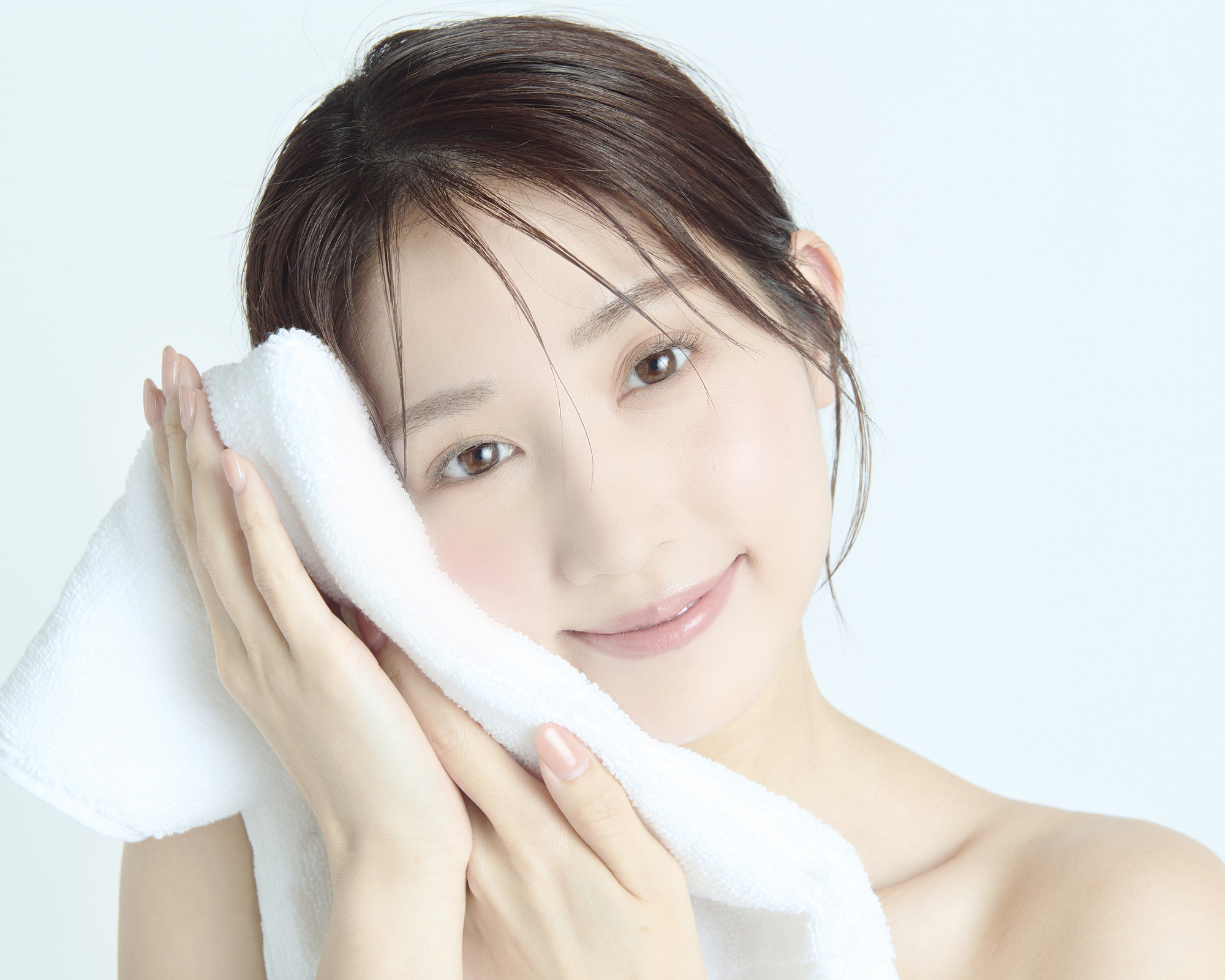 タオルで顔を拭く女性