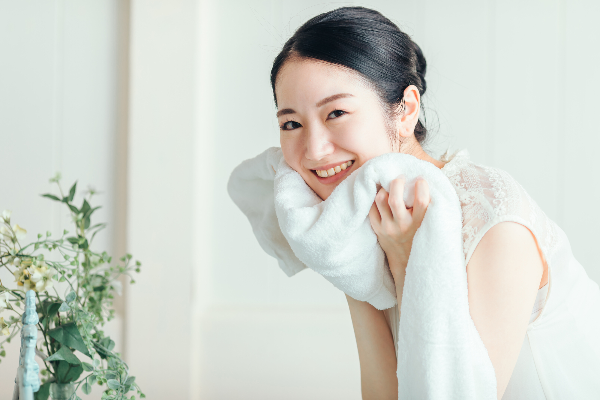 タオルで顔を拭く女性