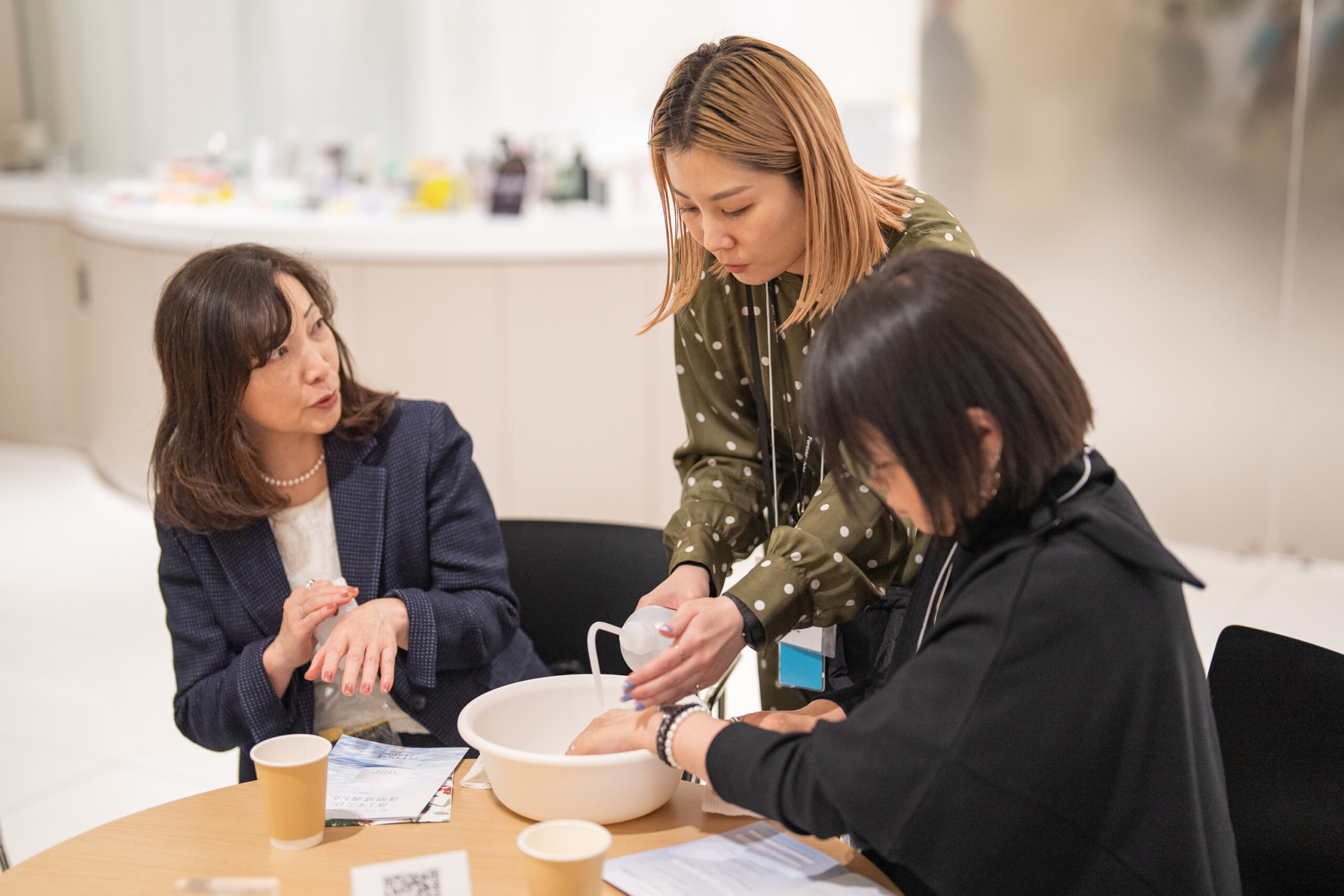 実際に新商品を試してみるお客様とサポートするPAスタッフ