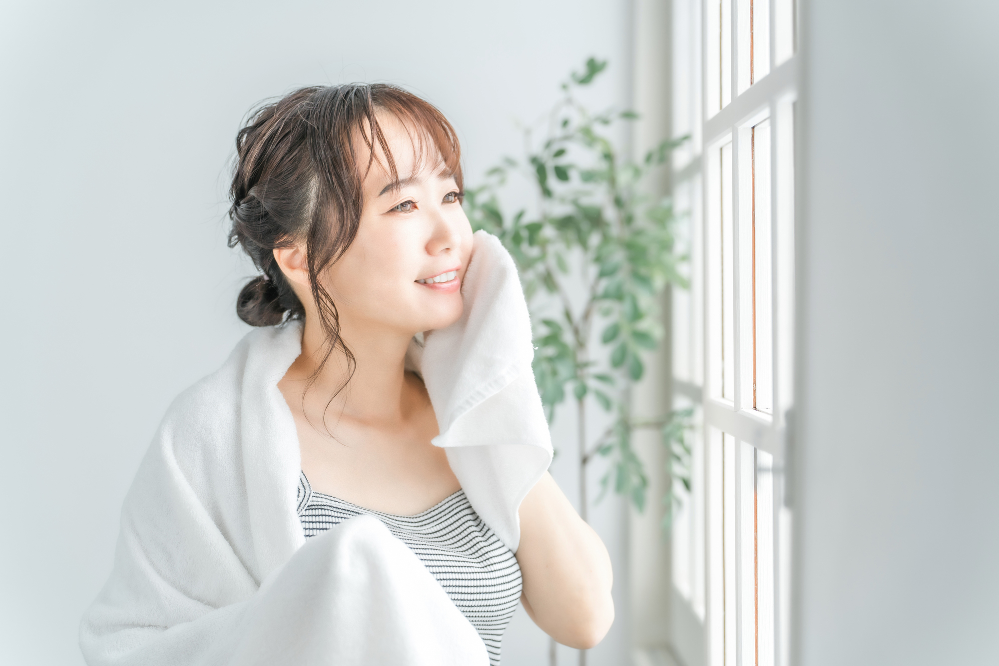 洗顔後タオルで顔を拭く女性
