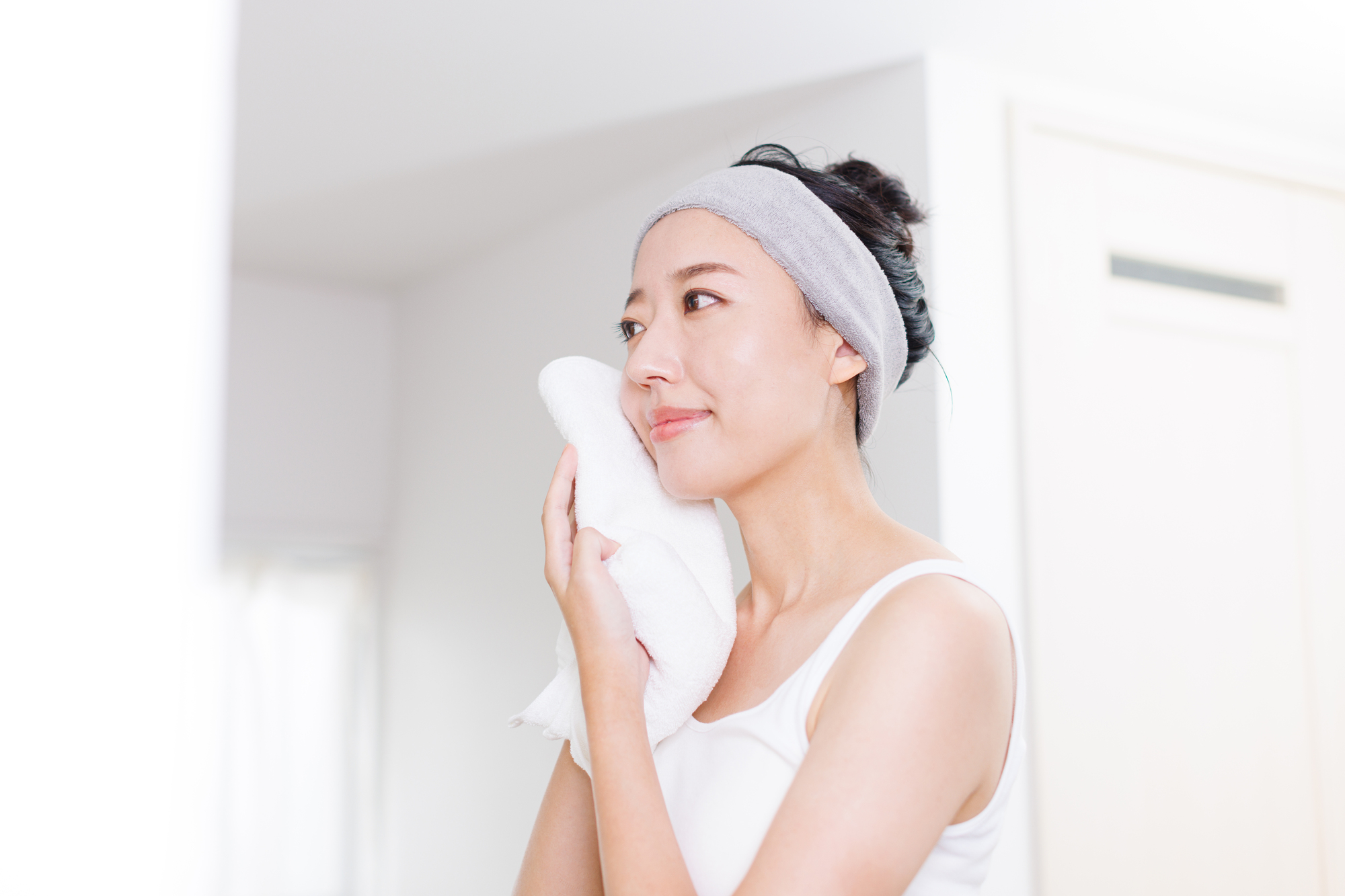 タオルで顔を拭く女性